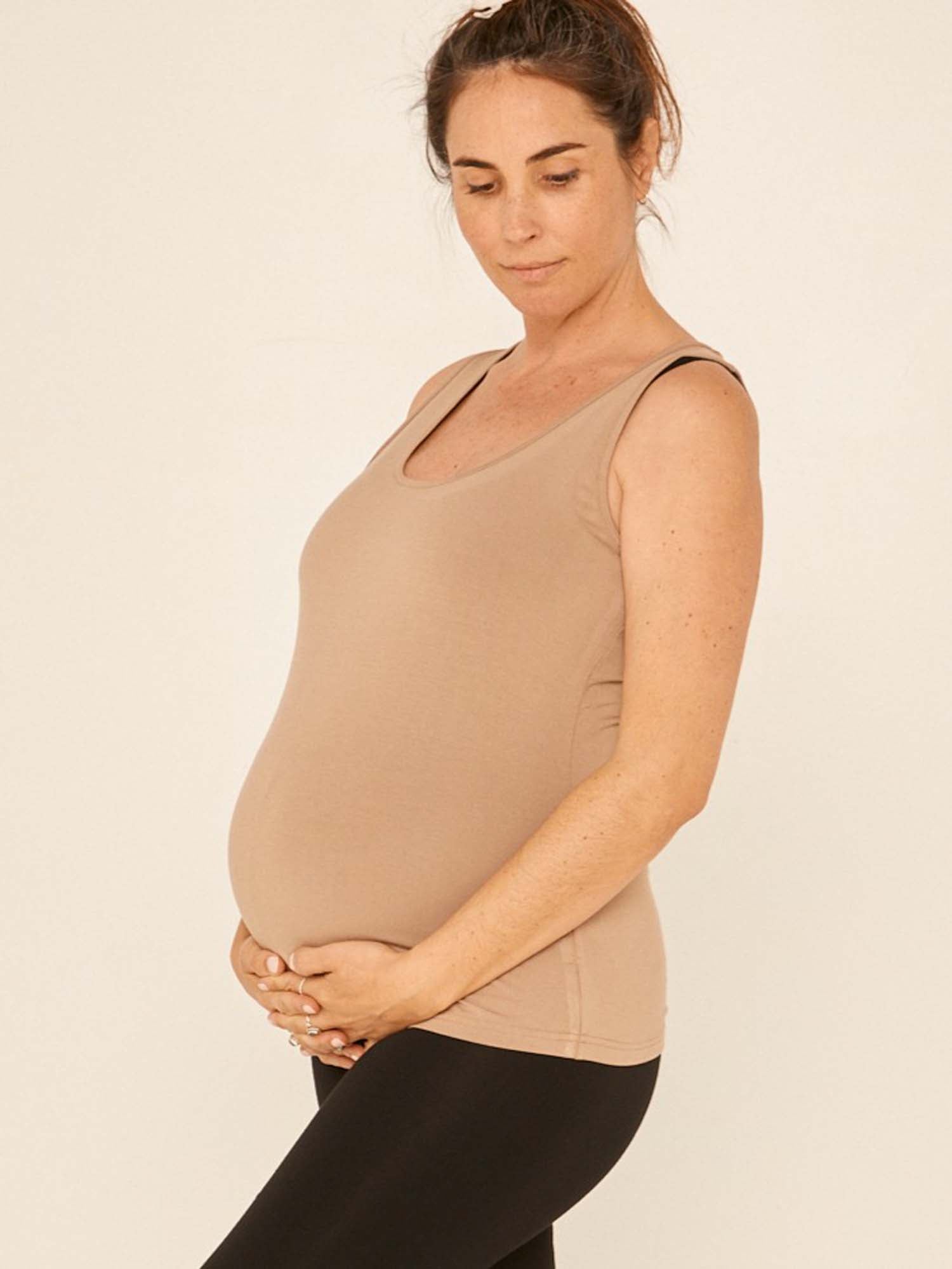 Model wearing a reversible caramel brown classic singlet with scoop and boat necklines and a fitted body, women's bamboo clothing