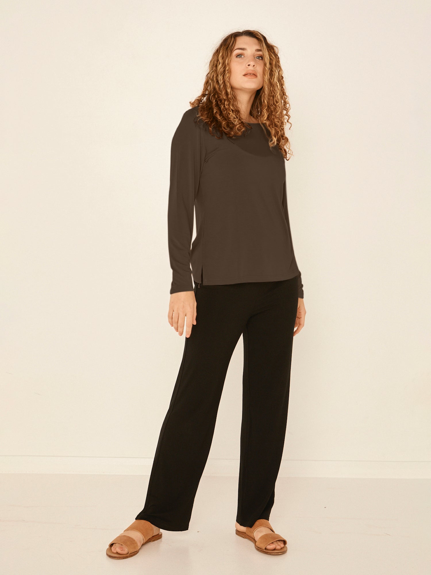Model wearing a cocoa brown boat neck long sleeve t-shirt, fitted through shoulders and chest with loose fit to waist, women's bamboo clothing