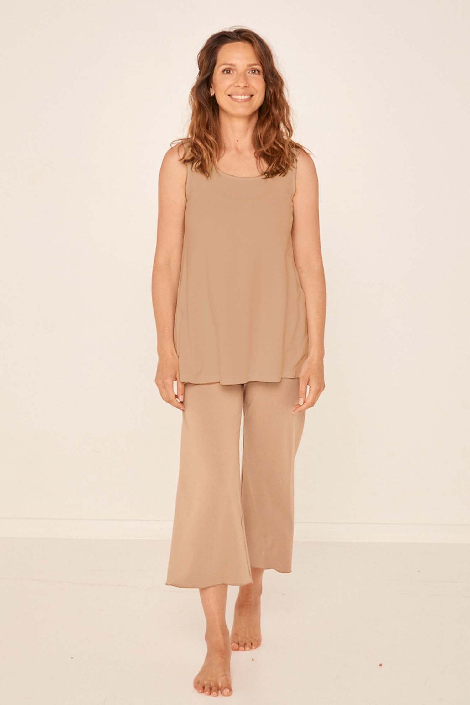Model wearing caramel 7/8 length resort pants, double layered adjustible high waistband, classic design, women's bamboo clothing