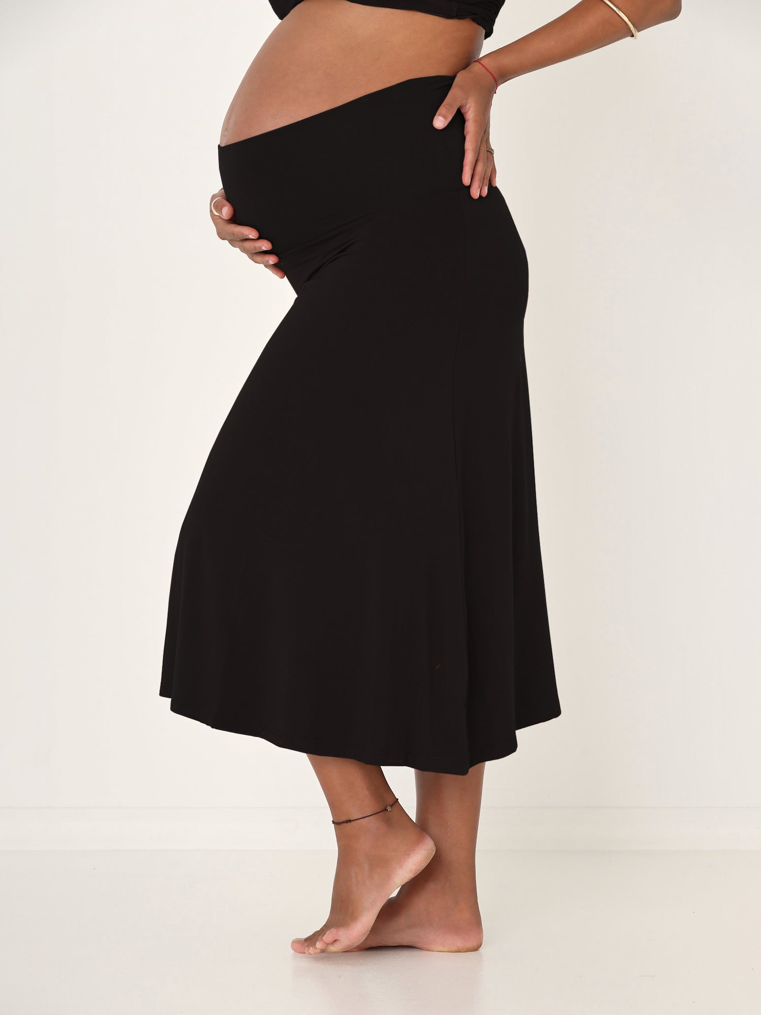 Model wearing black swing style long swishy skirt, mid - low calf length, double layered deep waistband, women's bamboo clothing