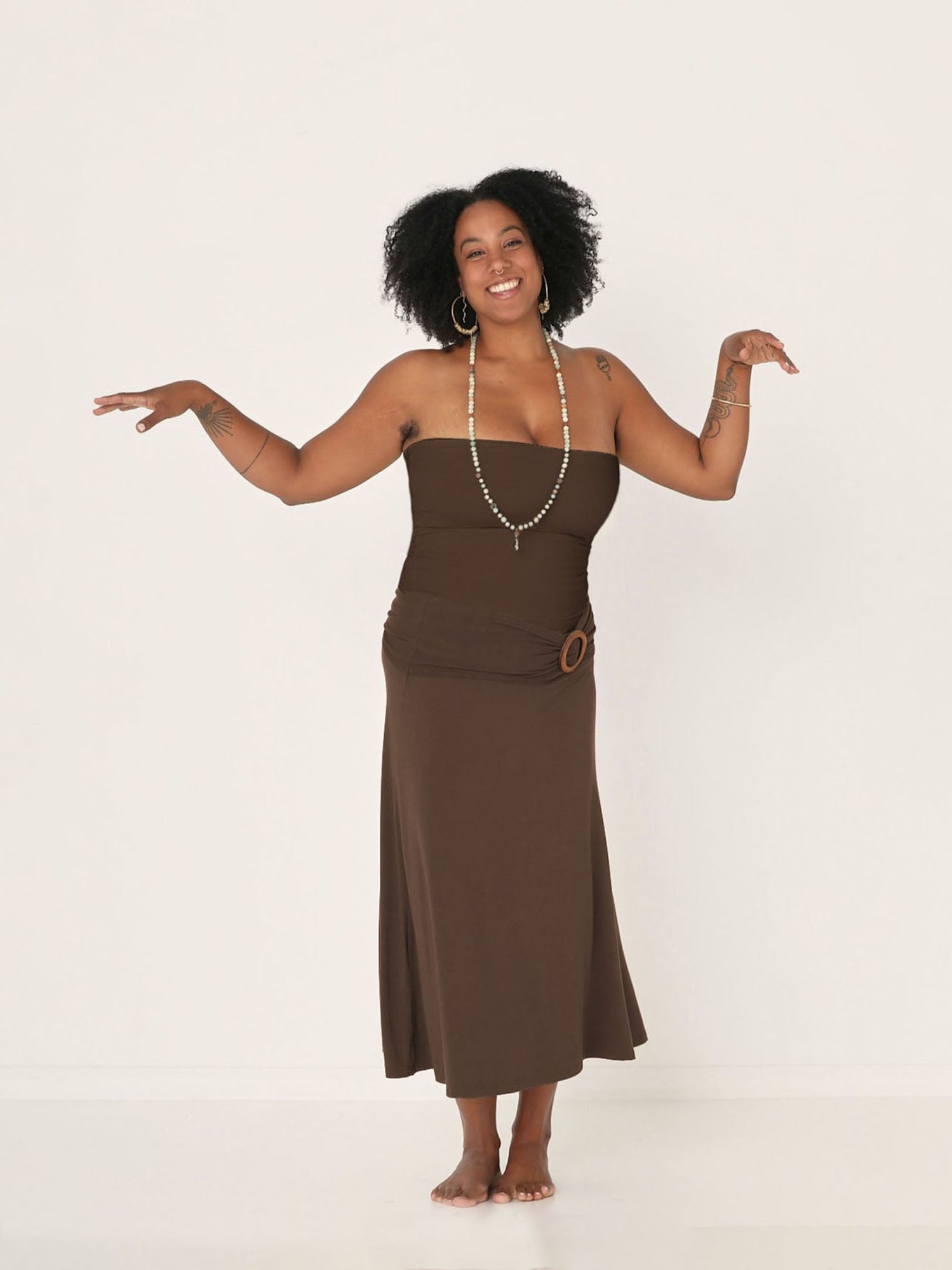 Model wearing cocoa swing style long swishy skirt, mid - low calf length, double layered deep waistband, worn with tube top and belt, women's bamboo clothing