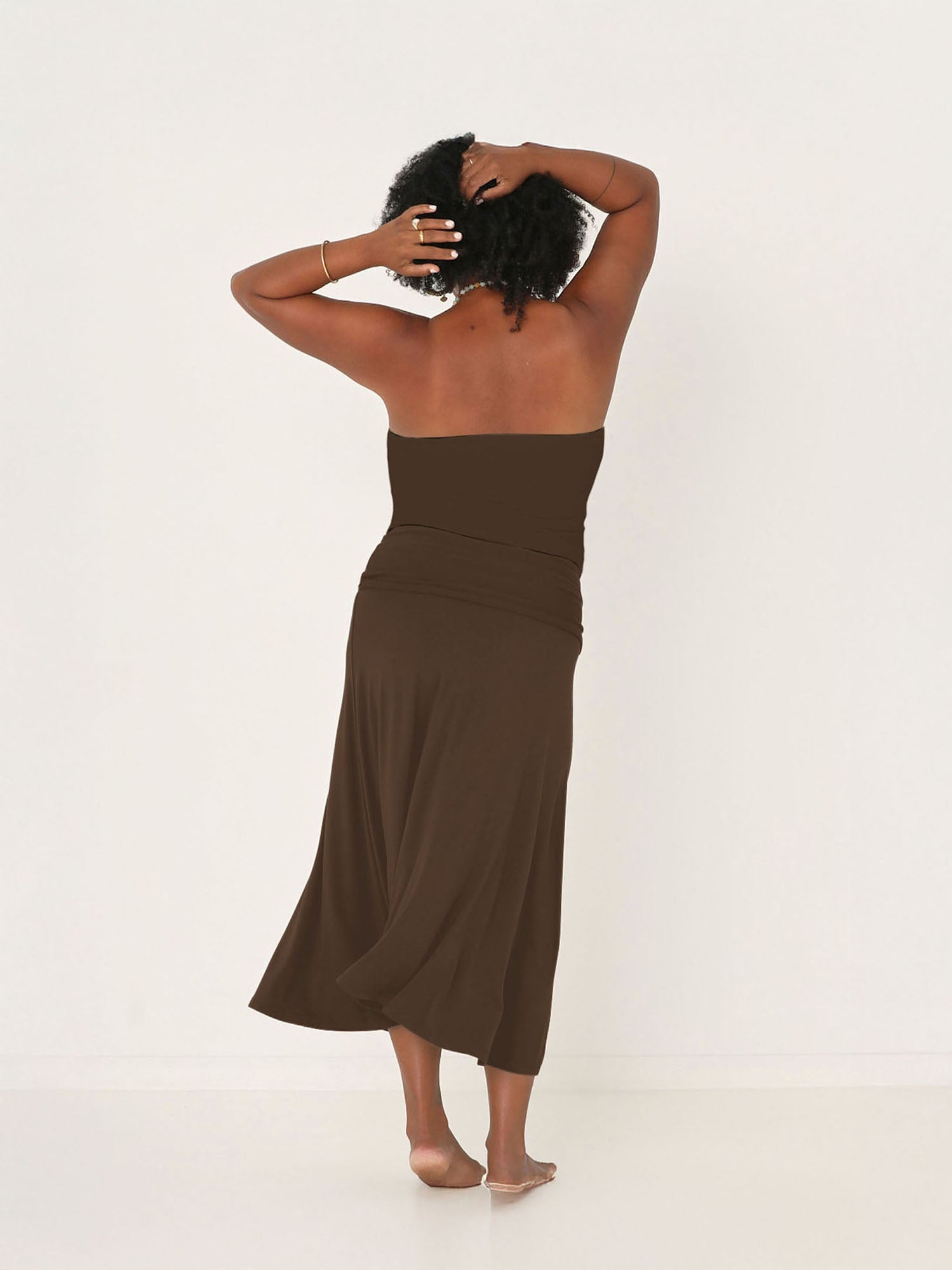 Model wearing cocoa swing style long swishy skirt, mid - low calf length, double layered deep waistband, worn with tube top and belt, women's bamboo clothing