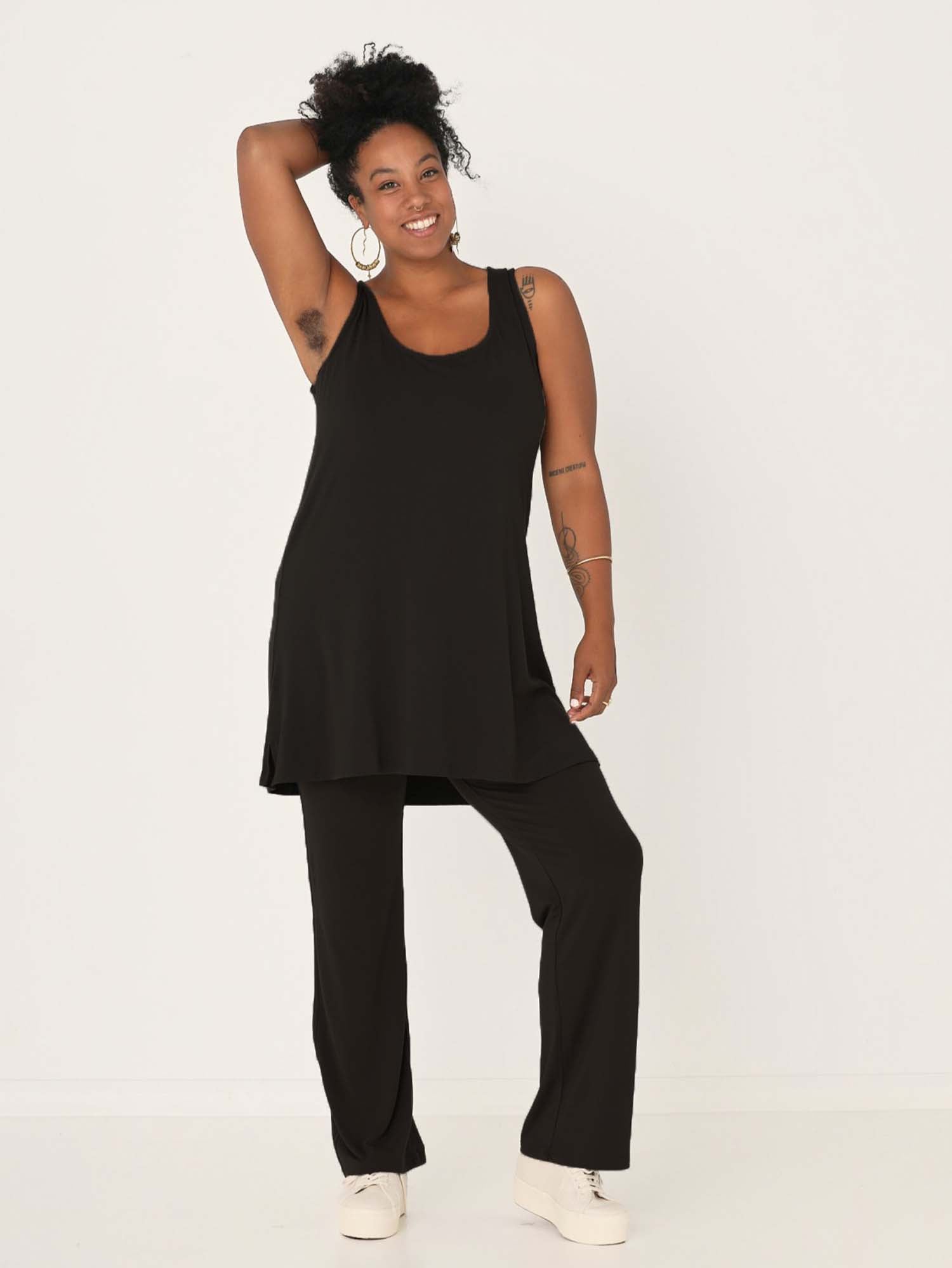 model wearing a black reversible sleeveless tunic with scoop and boat necklines, a-line singlet shape, mini length, women's bamboo clothing