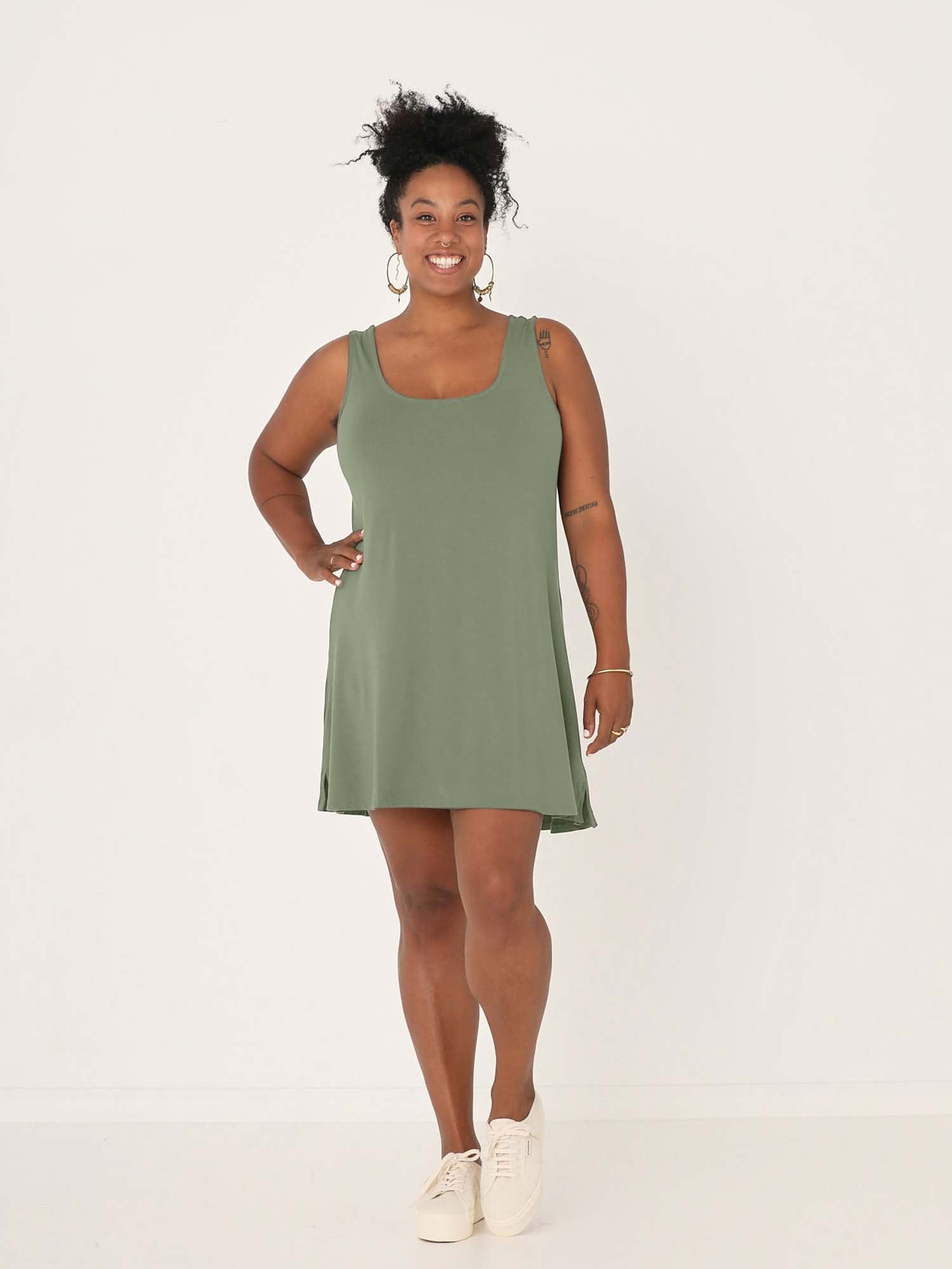 model wearing a eucalyptus green reversible sleeveless tunic with scoop and boat necklines, a-line shape, mini length, women's bamboo clothing