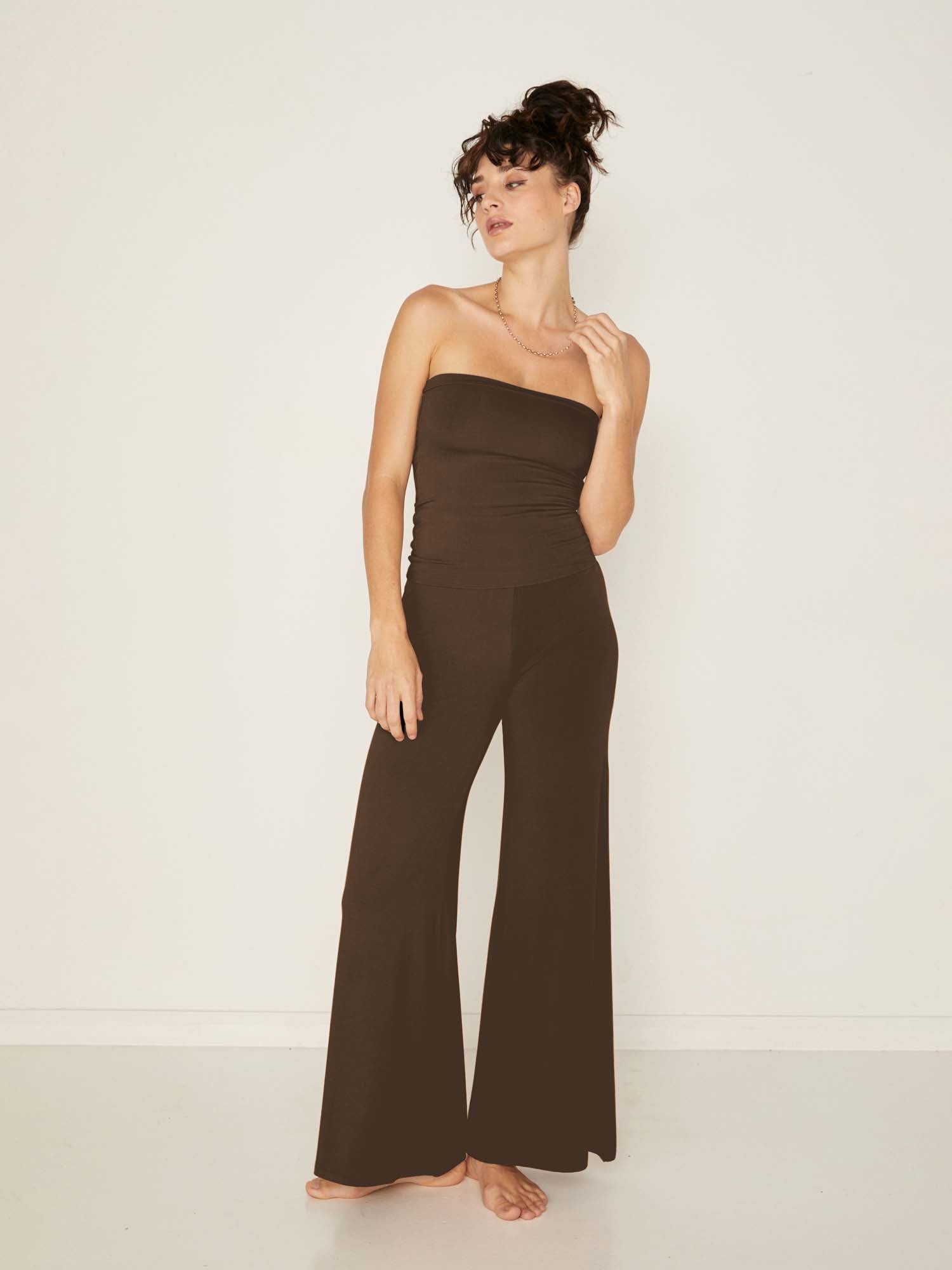 Model wearing cocoa full length palazzo pants, fitted waist and hips with flowing wide leg, adjustible high waistband, women's bamboo clothing