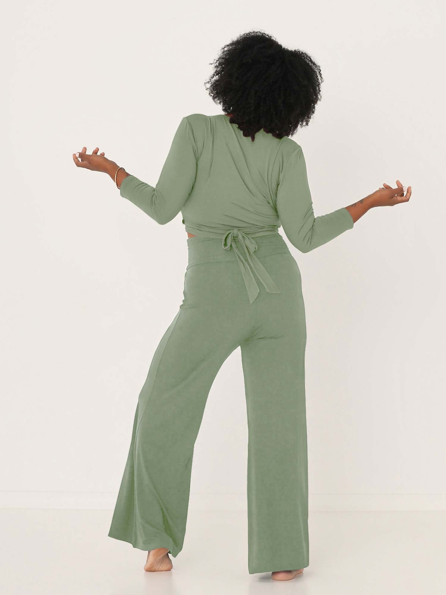 Model wearing eucalyptus full length palazzo pants, fitted waist and hips with flowing wide leg, adjustible high waistband, women's bamboo clothing