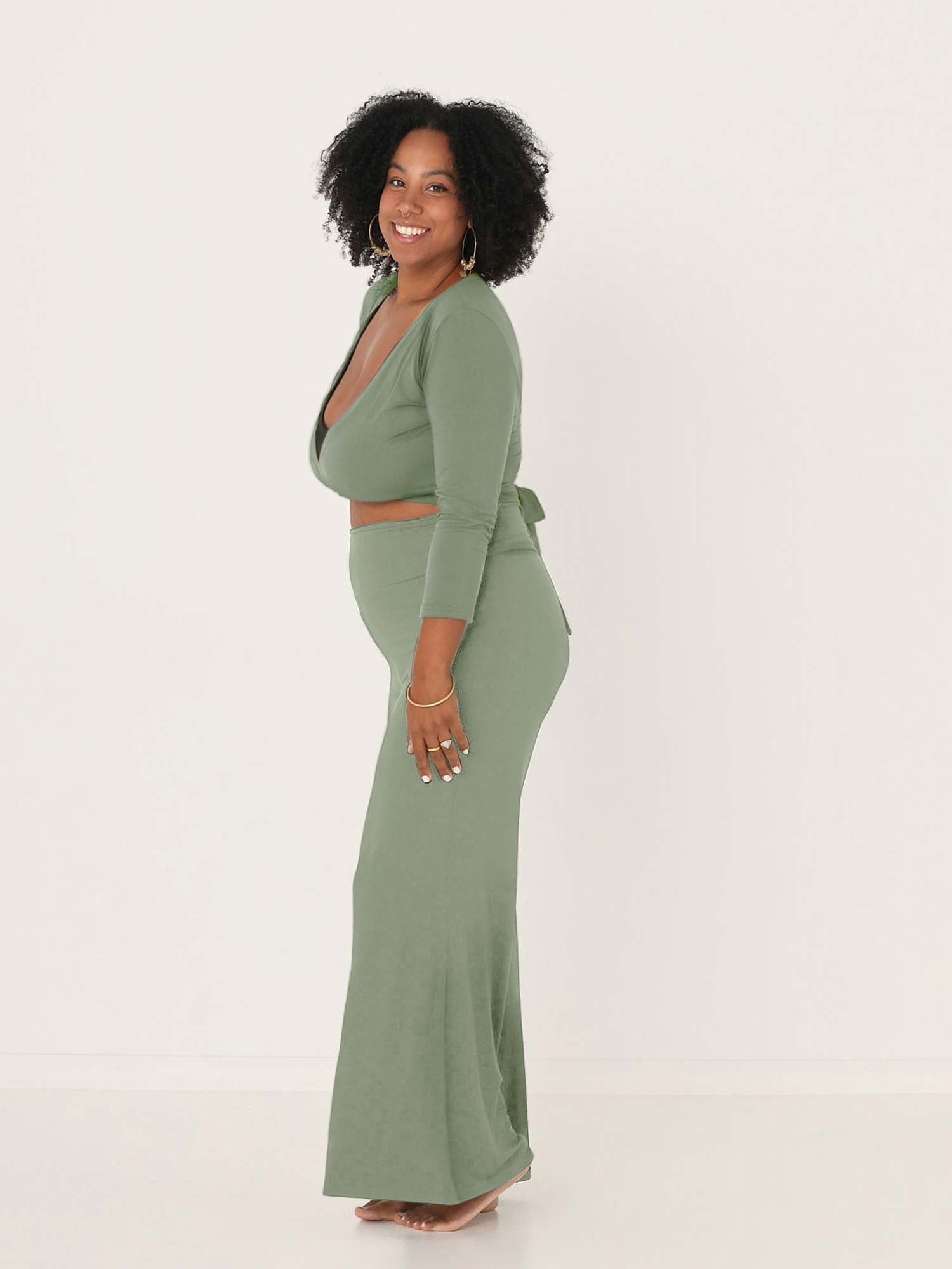 Model wearing eucalyptus full length palazzo pants, fitted waist and hips with flowing wide leg, adjustible high waistband, women's bamboo clothing