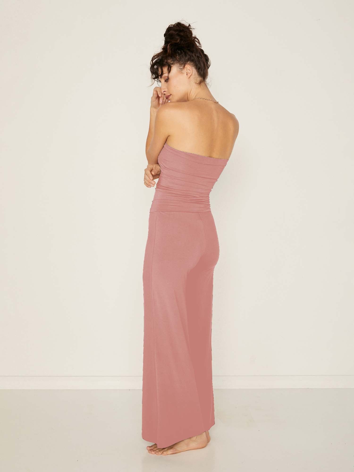 Model wearing pink full length palazzo pants, fitted waist and hips with flowing wide leg, adjustible high waistband, women's bamboo clothing