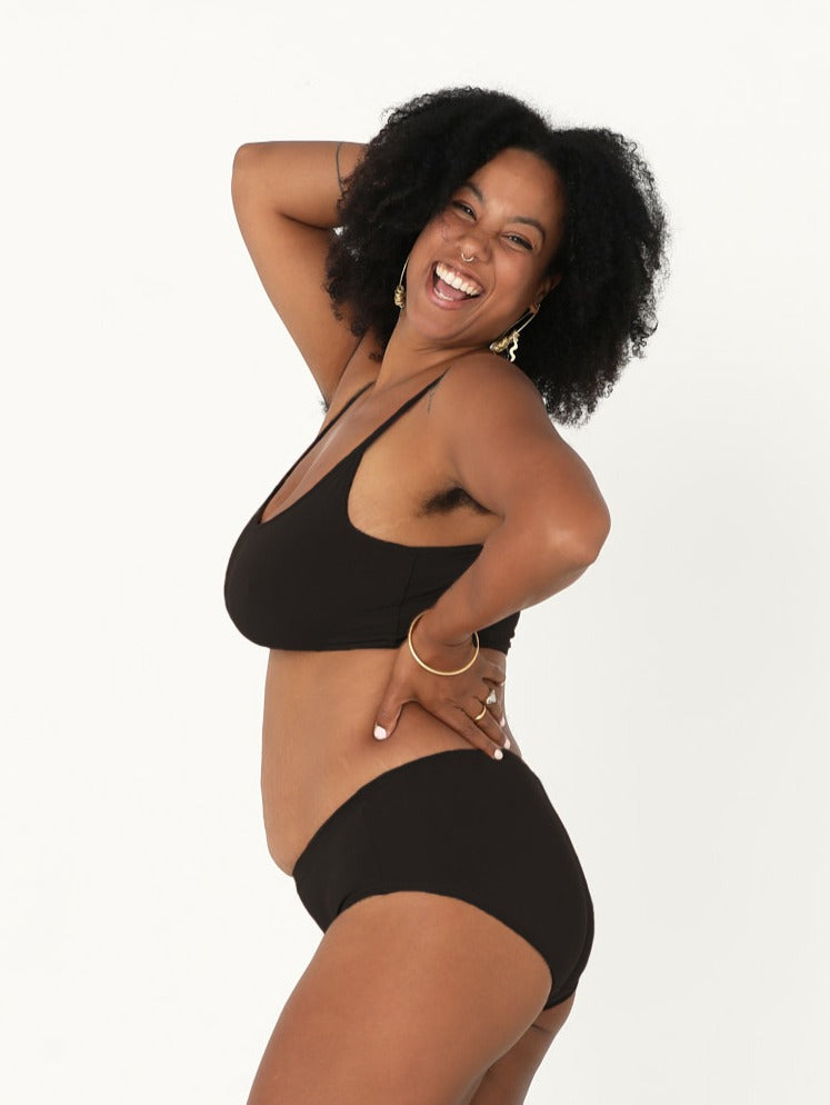 Model wearing a black wireless yoga bra, subtle v front, soft cup bralette with adjustable camisole straps, women's bamboo underwear