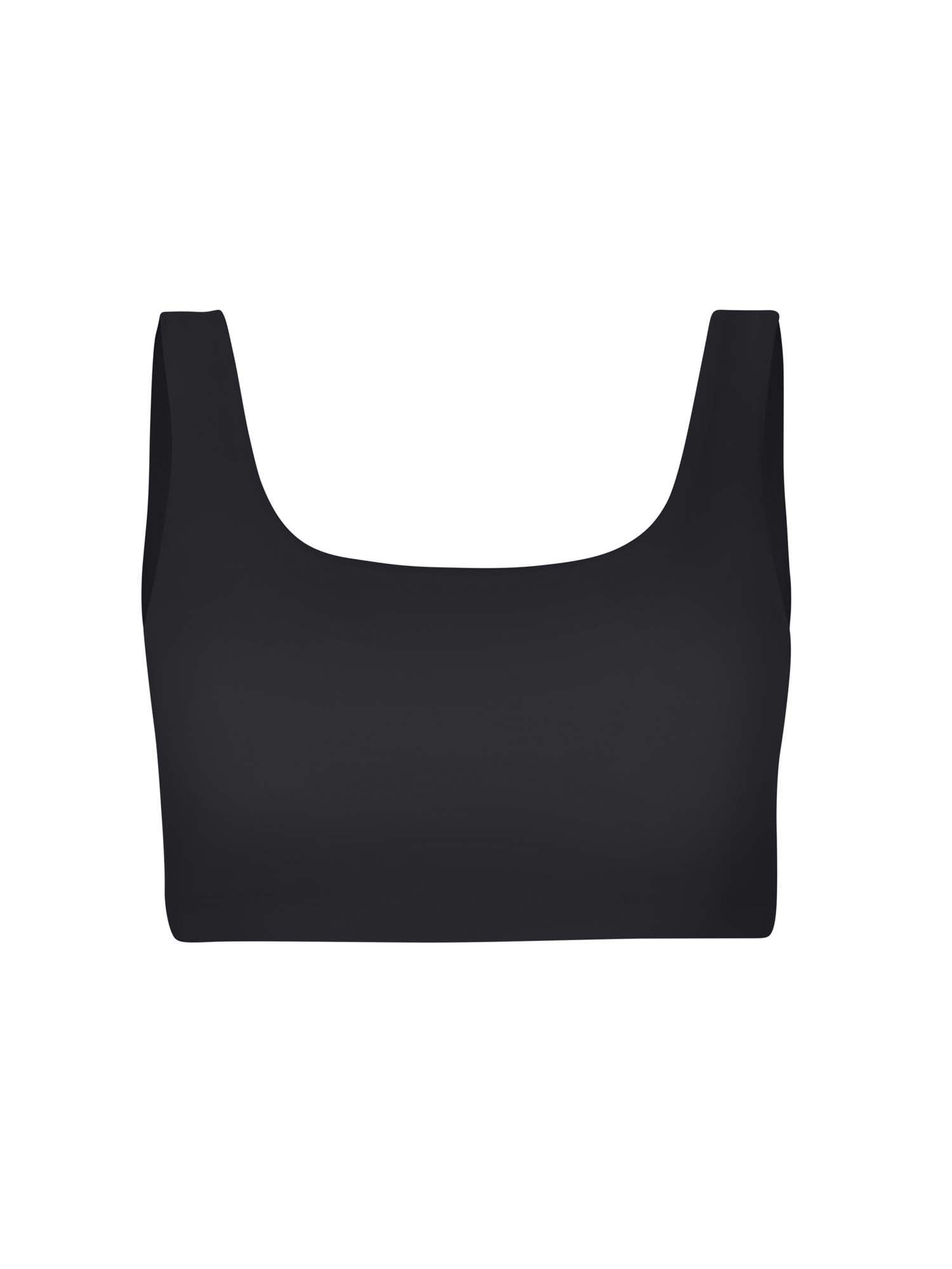 Model wearing black reversible bra, high or low scoop neckline and wide shoulder straps, wireless bra, women's bamboo underwear