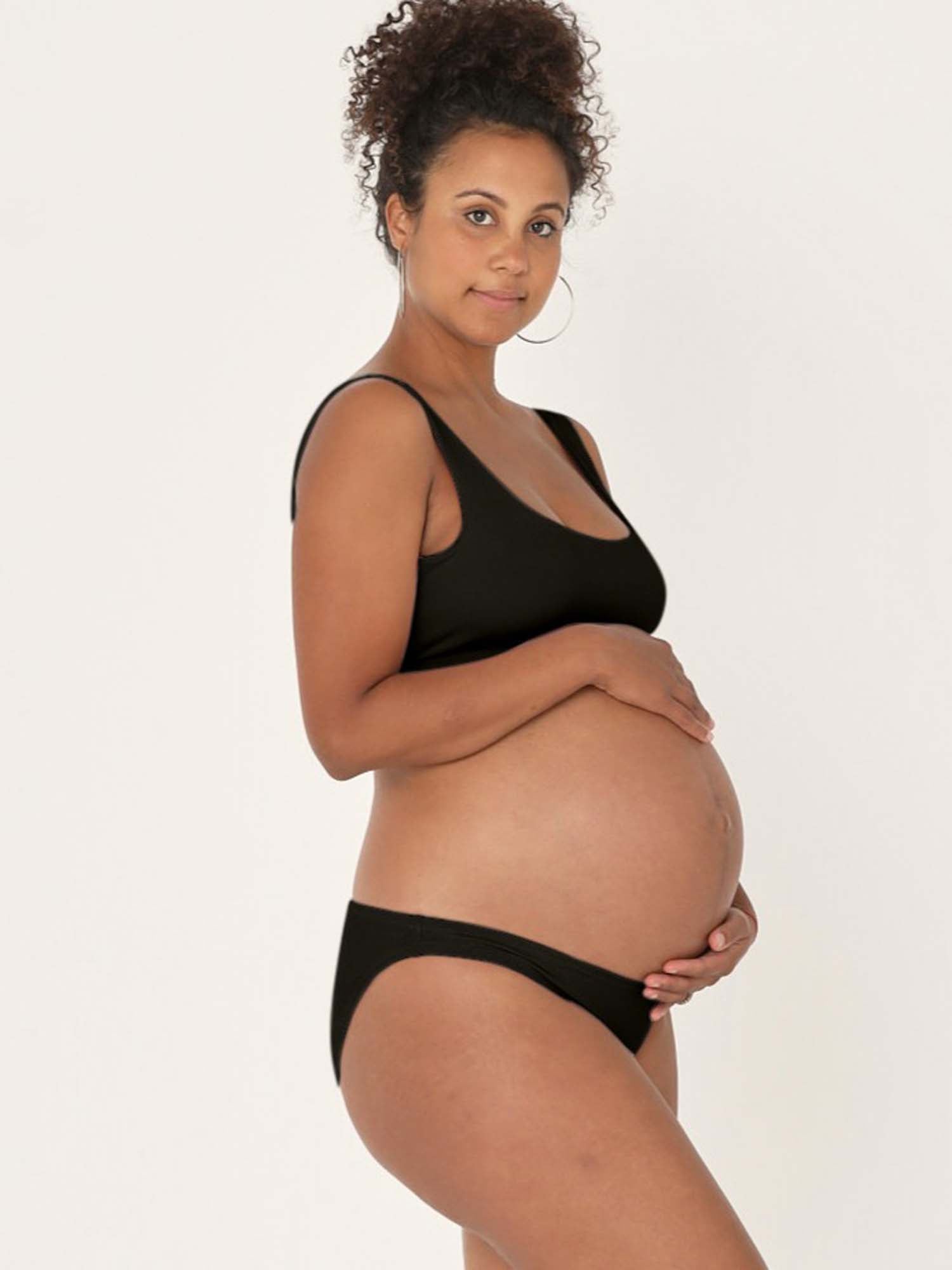 Model wearing black reversible bra, high or low scoop neckline and wide shoulder straps, wireless bra, women's bamboo underwear