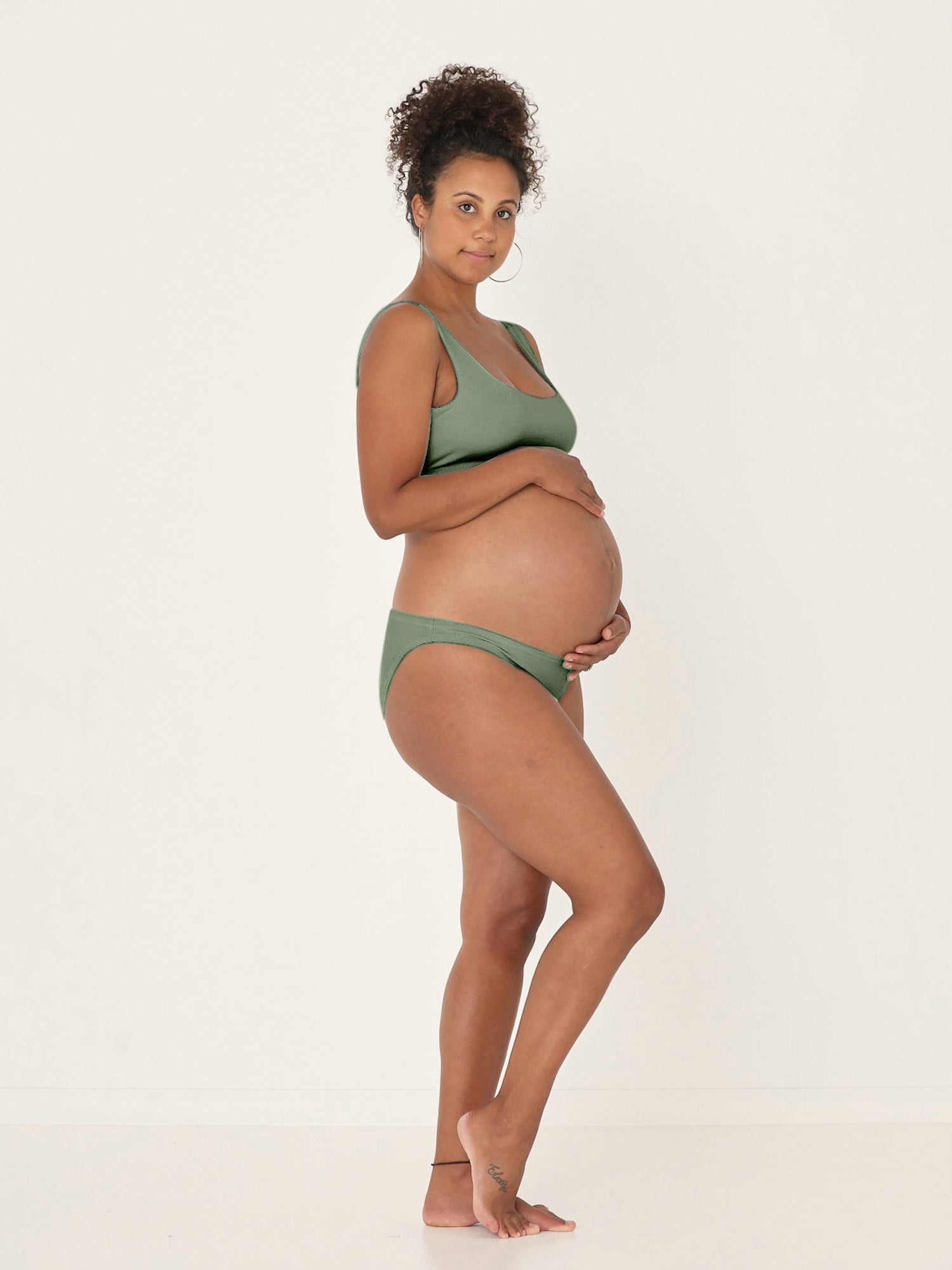 Model wearing eucalyptus green reversible bra, high or low scoop neckline and wide shoulder straps, wireless bra, women's bamboo underwear