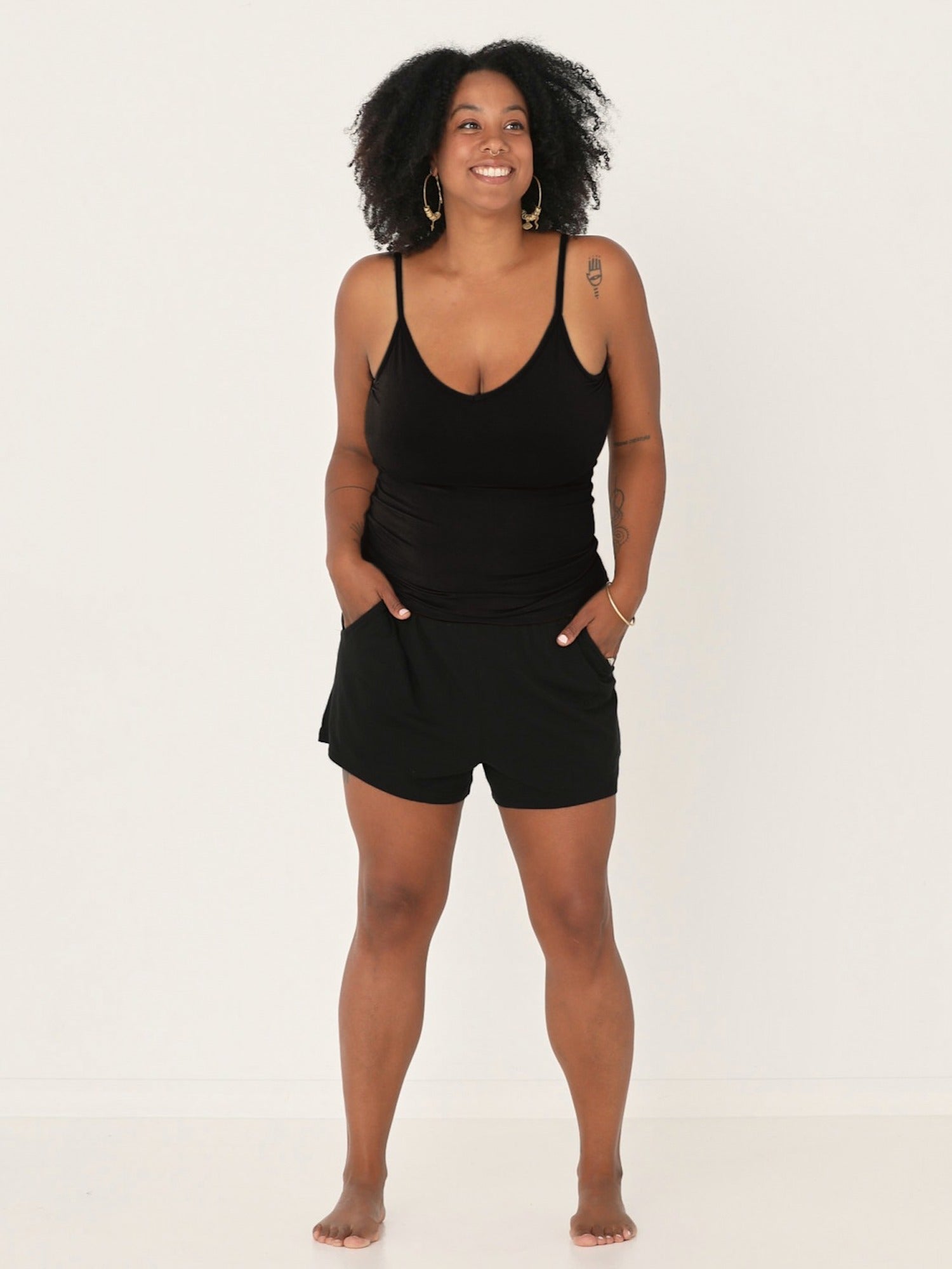 Model wearing black body singlet with in-built bralette, subtle v front and adjustable straps, women's bamboo clothing