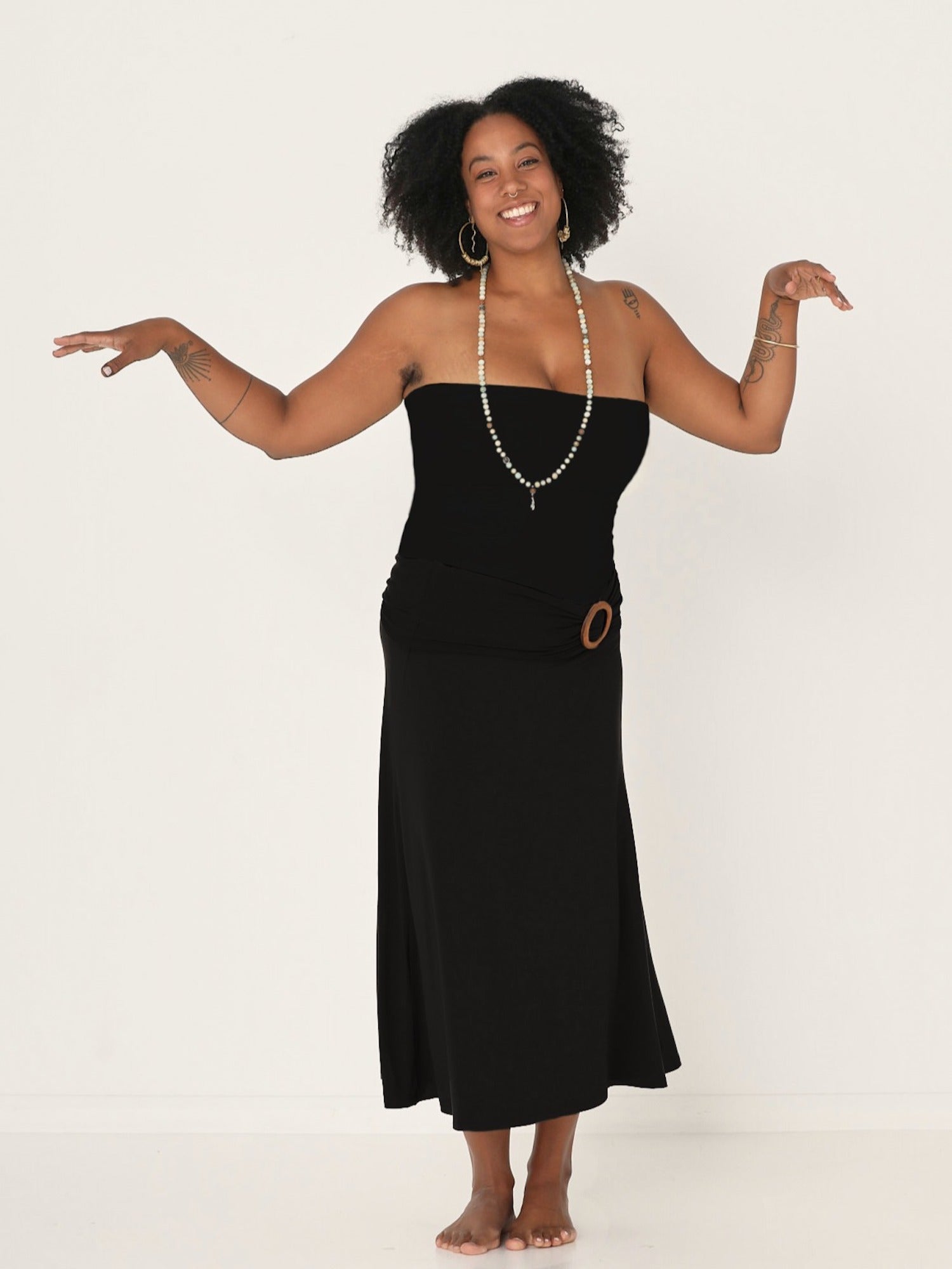 Model wearing black bamboo fabric belt with round natural brown wooden buckle, women's bamboo clothing accessories
