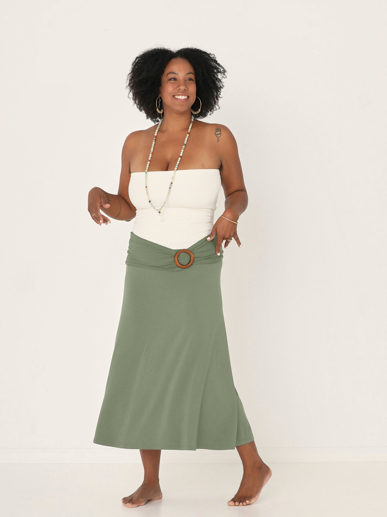 Model wearing eucalyptus green bamboo fabric belt with round natural brown wooden buckle, women's bamboo clothing accessories