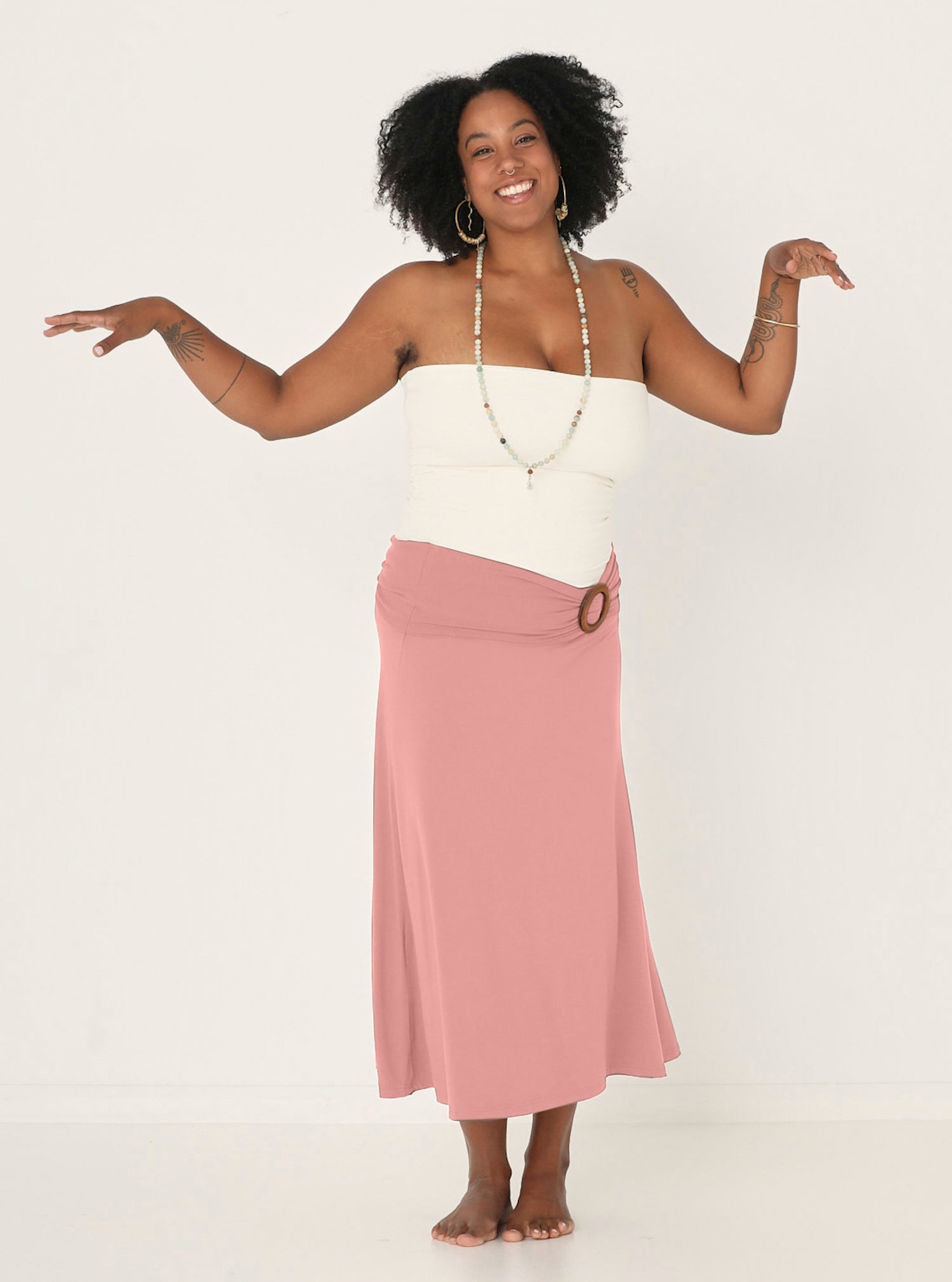 Model wearing dusty pink bamboo fabric belt with round natural brown wooden buckle, women's bamboo clothing accessories