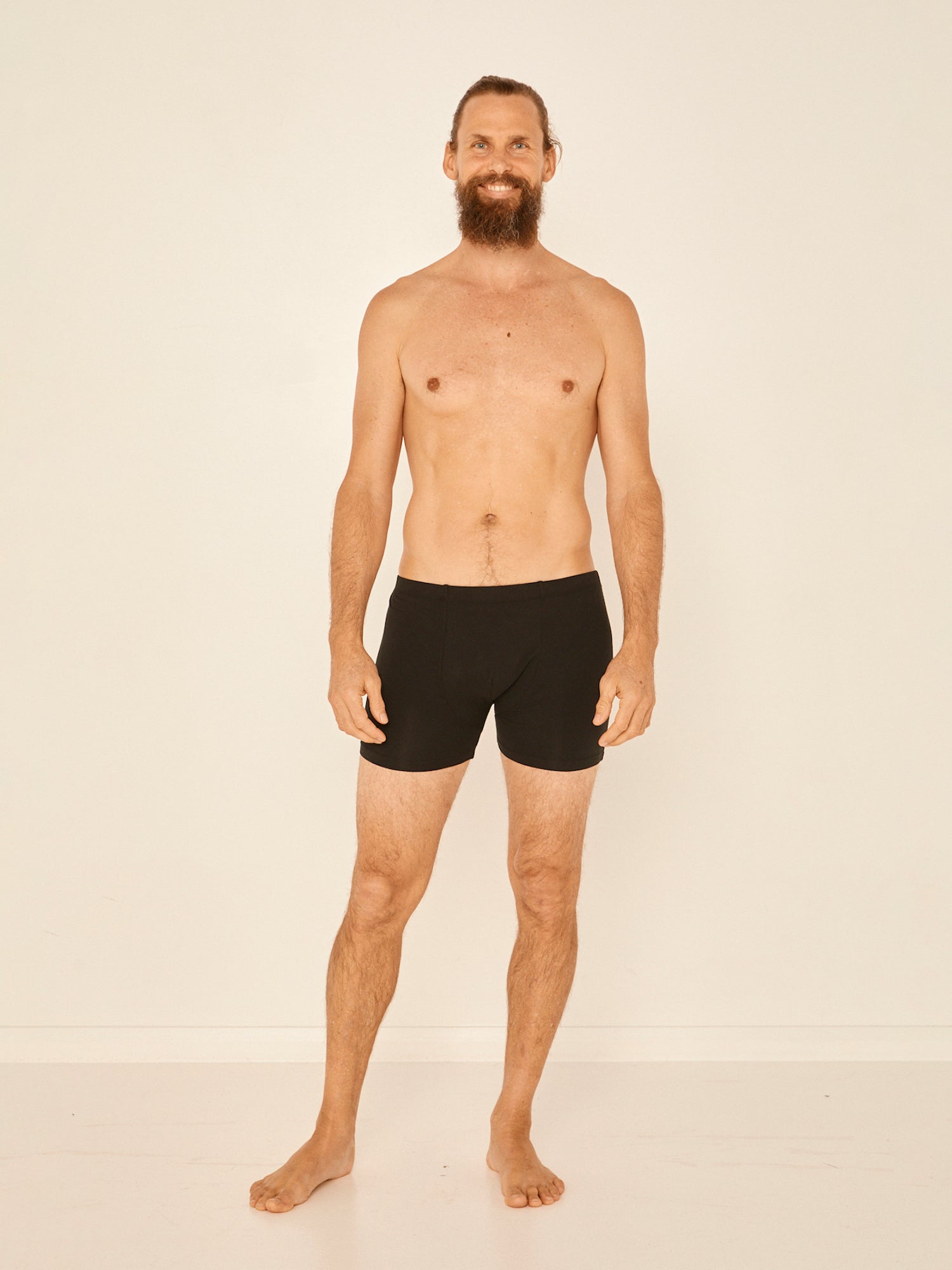 Male model wearing black trunk style boxer shorts with a soft elasticated waistband and pouch detail stiching, men's bamboo underwear
