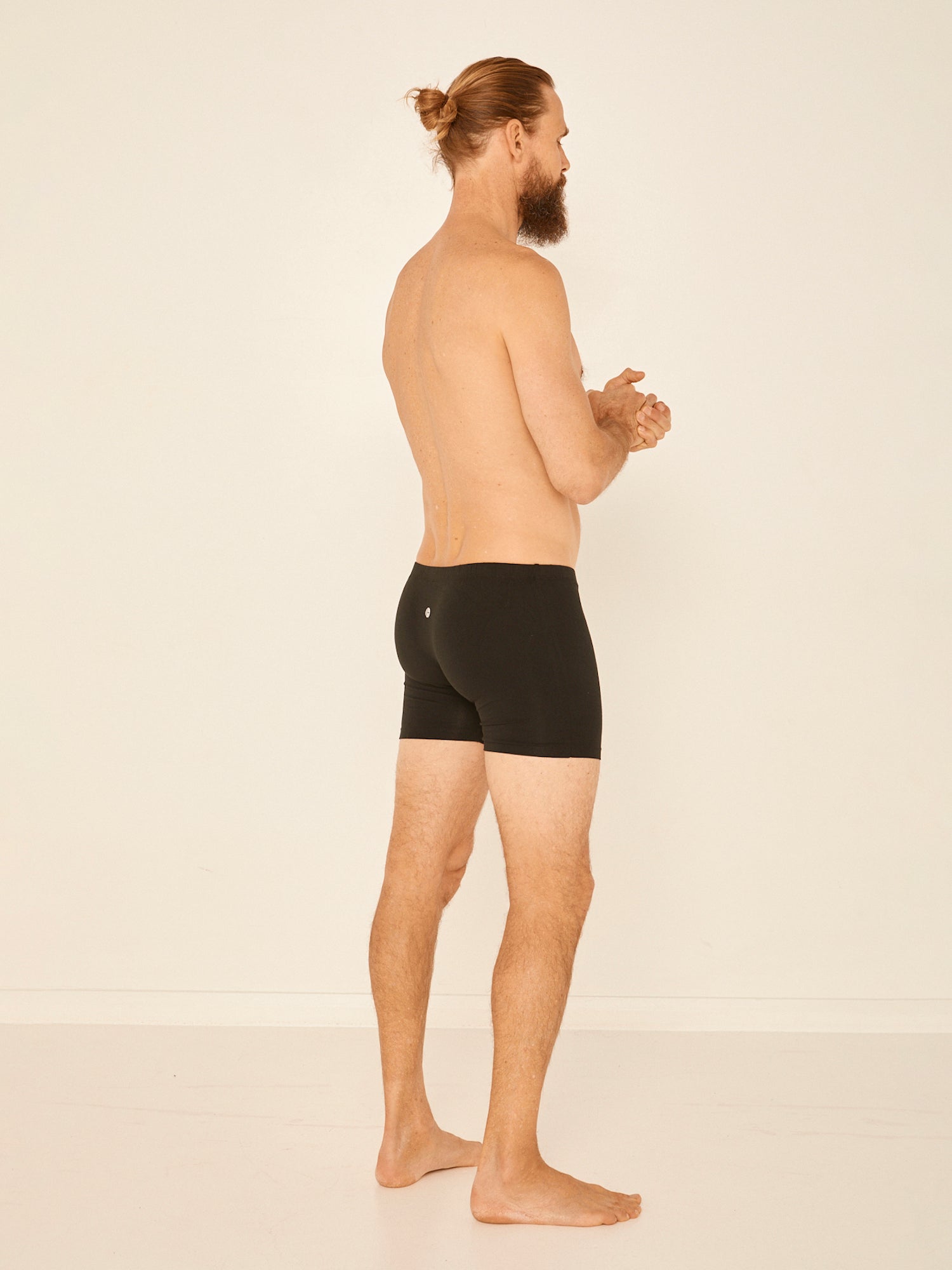 Male model wearing black trunk style boxer shorts with a soft elasticated waistband and pouch detail stiching, men's bamboo underwear