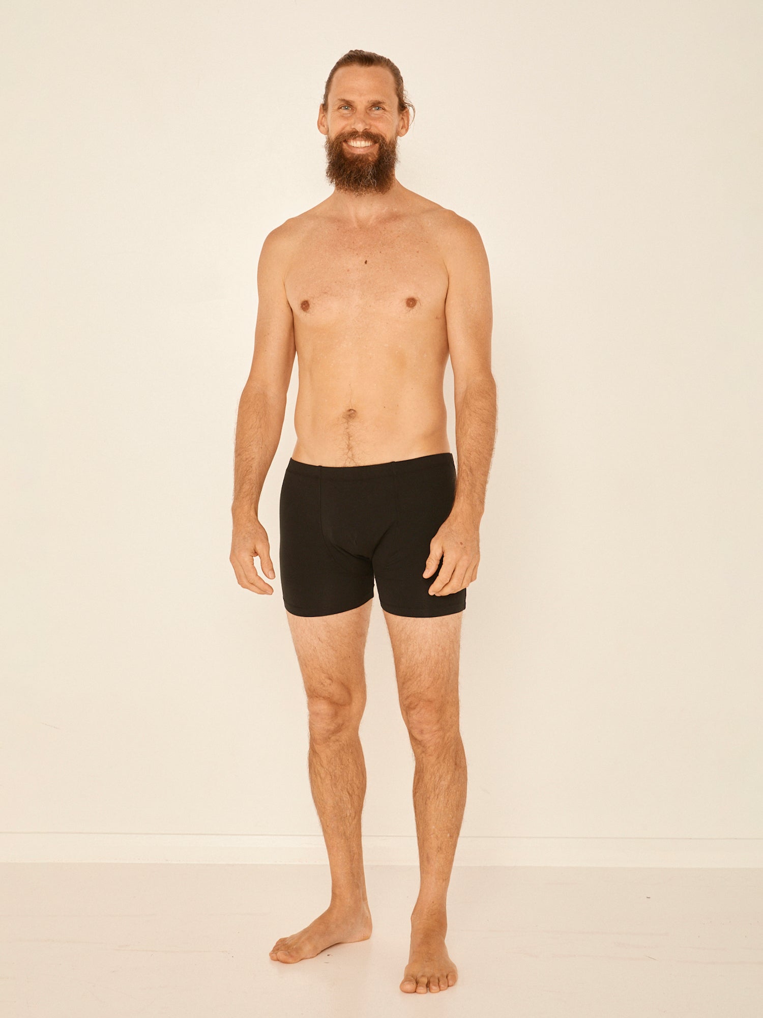 Male model wearing black trunk style boxer shorts with a soft elasticated waistband and pouch detail stiching, men's bamboo underwear