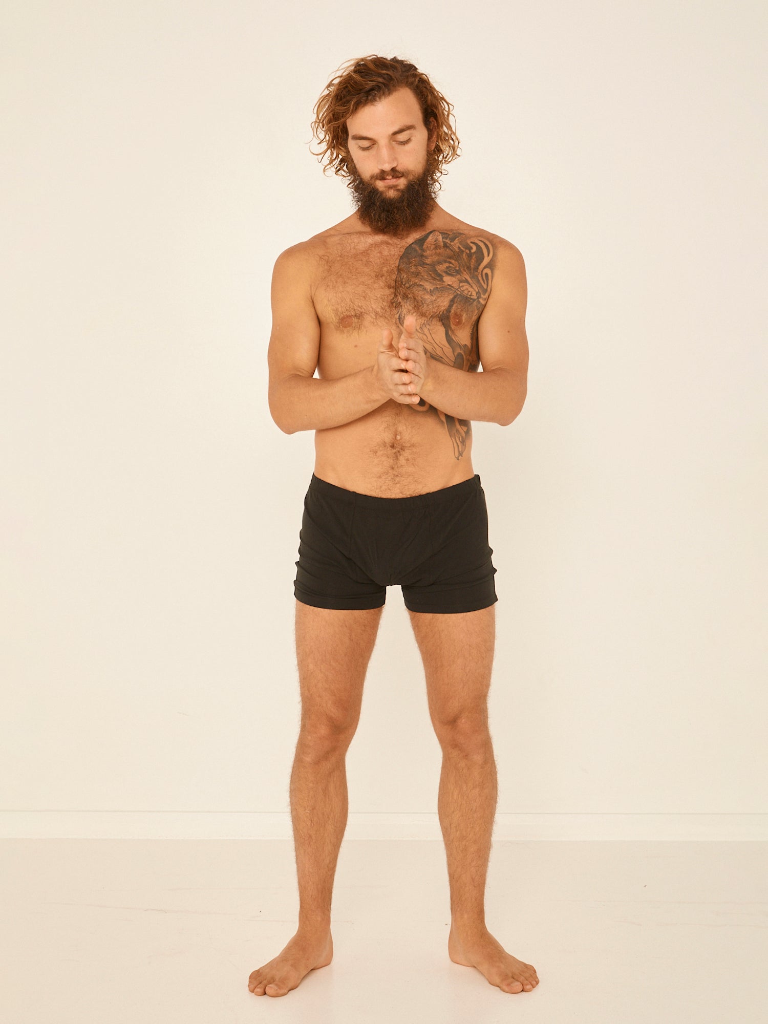 Male model wearing black trunk style boxer shorts with a soft elasticated waistband and pouch detail stiching, men's bamboo underwear