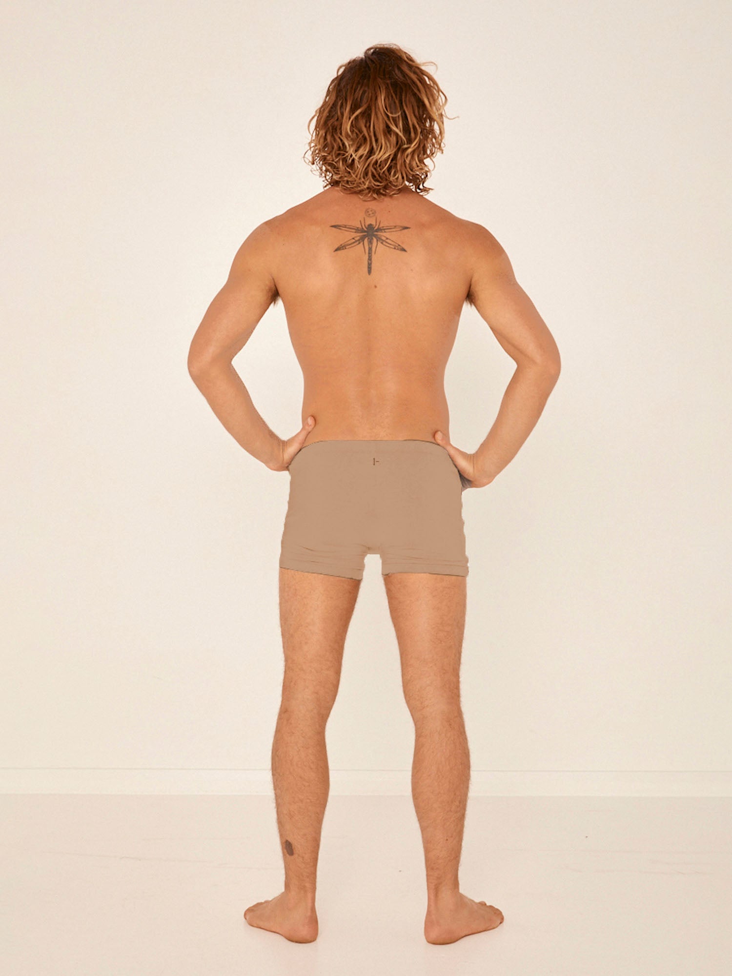 Male model wearing caramel trunk style boxer shorts with a soft elasticated waistband and pouch detail stitching, men's bamboo underwear