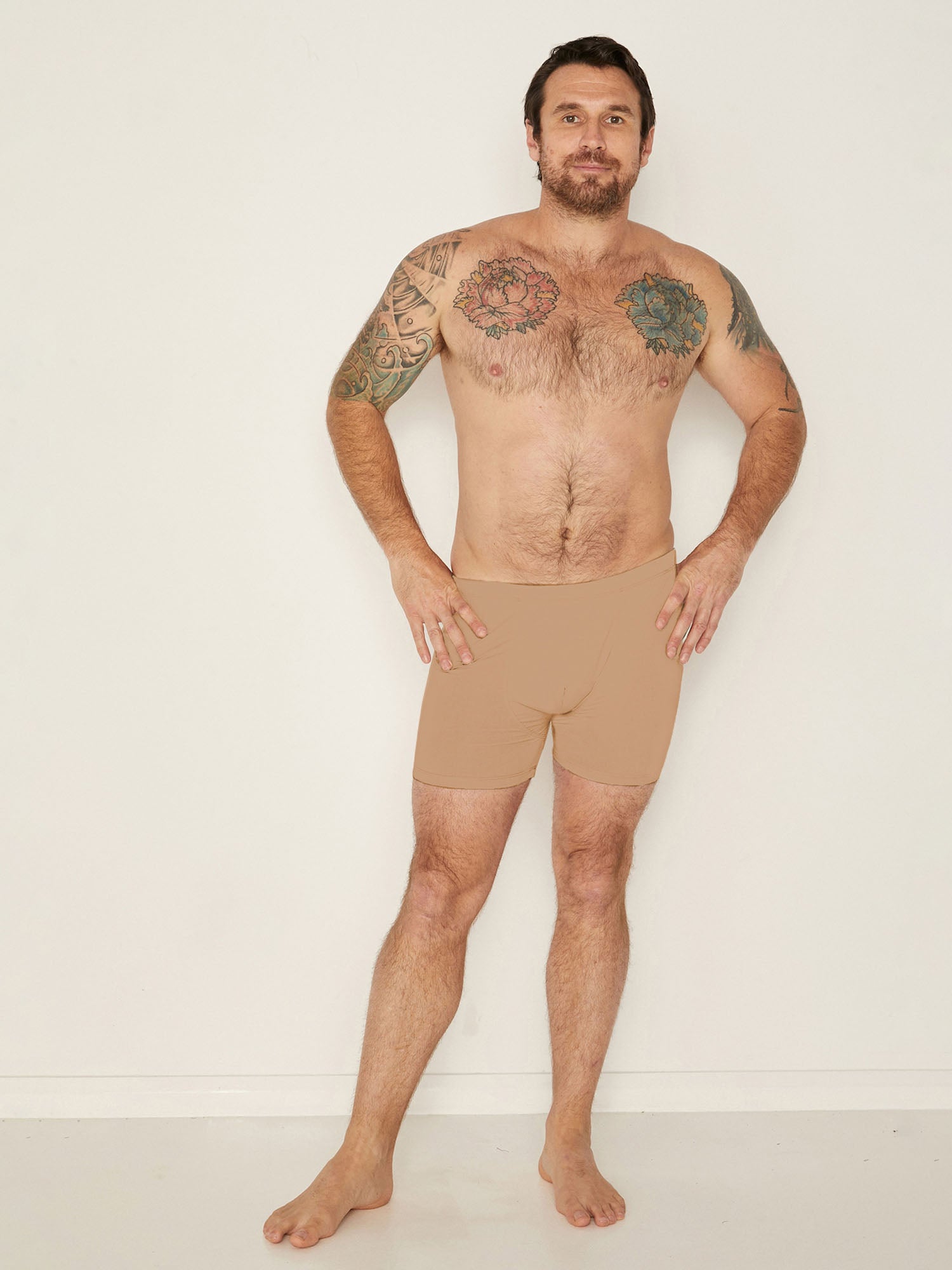 Male model wearing caramel trunk style boxer shorts with a soft elasticated waistband and pouch detail stitching, men's bamboo underwear
