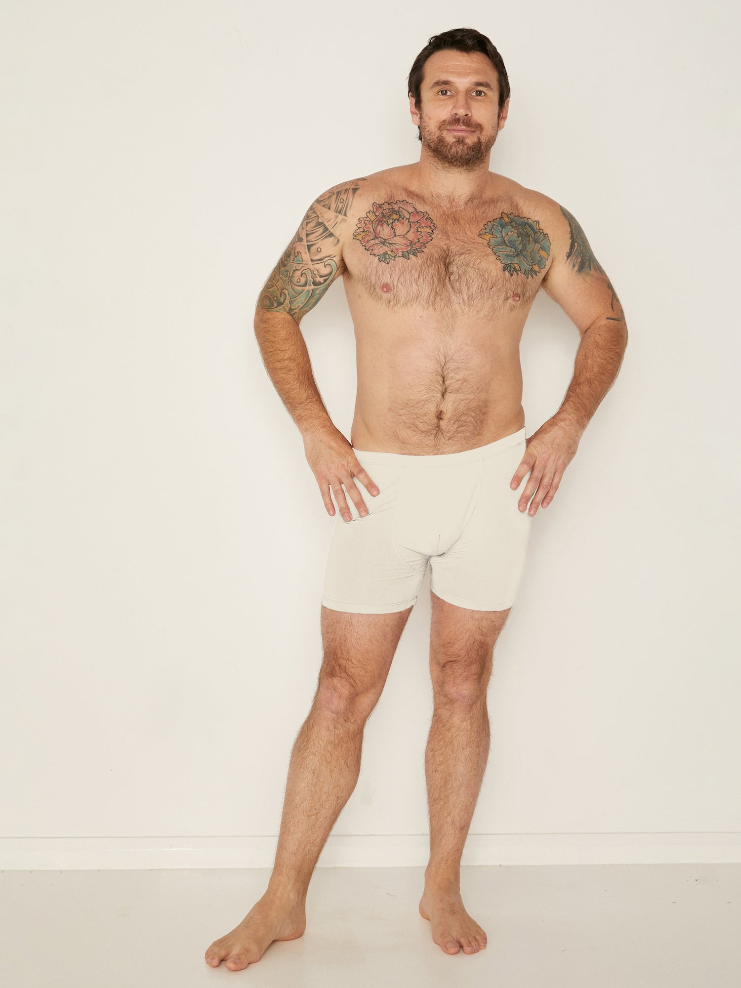 Male model wearing cream trunk style boxer shorts with a soft elasticated waistband and pouch detail stiching, men's bamboo underwear