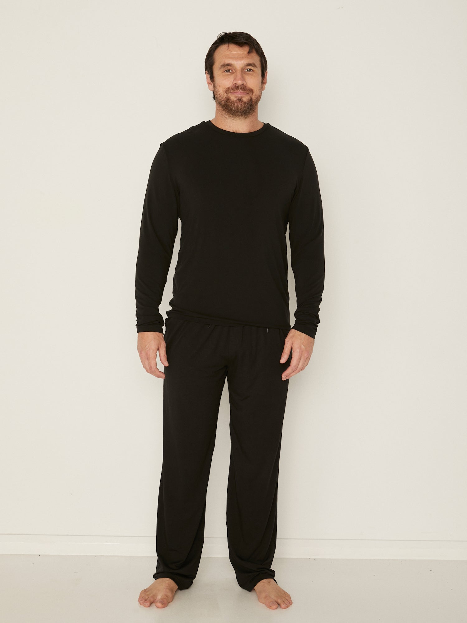 Male model full length black casual pants with elasticised waist, relaxed loose leg and deep pockets, men's bamboo clothing