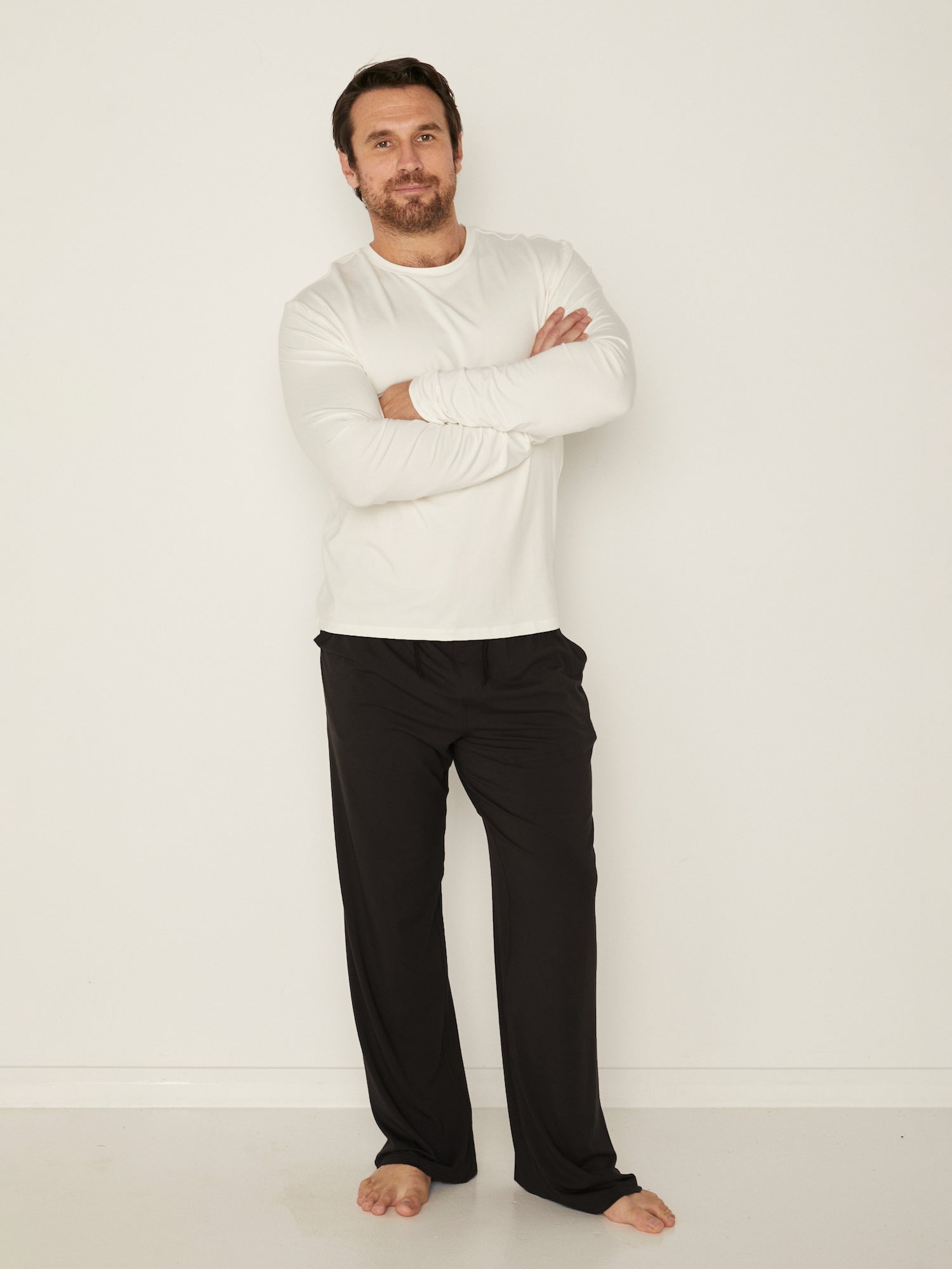Male model wearing cream classic long sleeve t-shirt, generous fit, soft neckband, crew neckline, men's bamboo clothing
