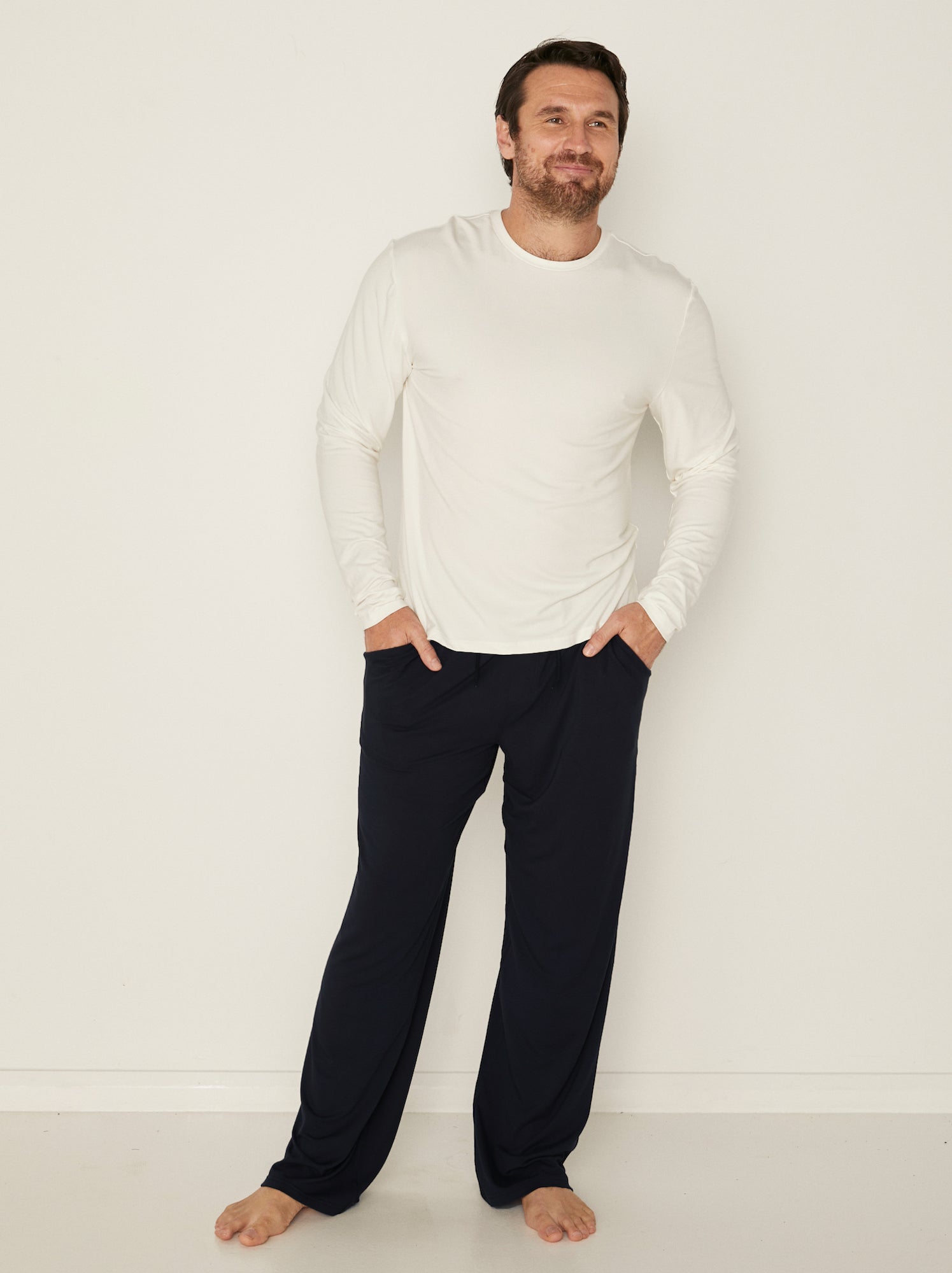 Male model wearing cream classic long sleeve t-shirt, generous fit, soft neckband, crew neckline, men's bamboo clothing