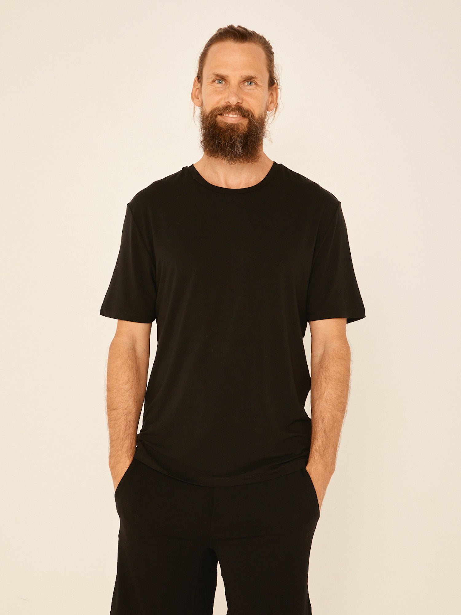 Male model wearing black generous classic fit tee, soft neckband, crew neckline, short sleeve, men's bamboo clothing