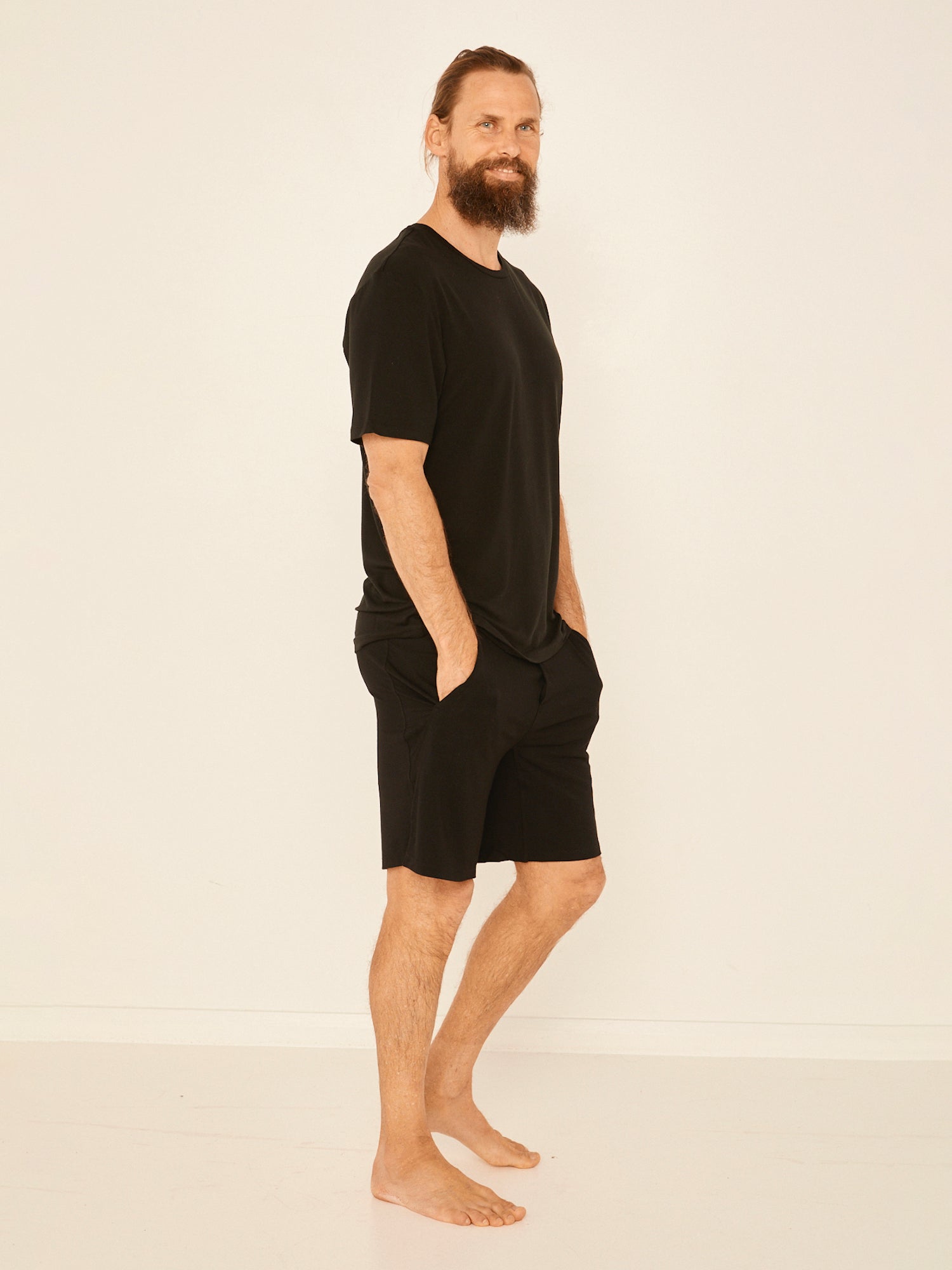 Male model wearing black generous classic fit tee, soft neckband, crew neckline, short sleeve, men's bamboo clothing