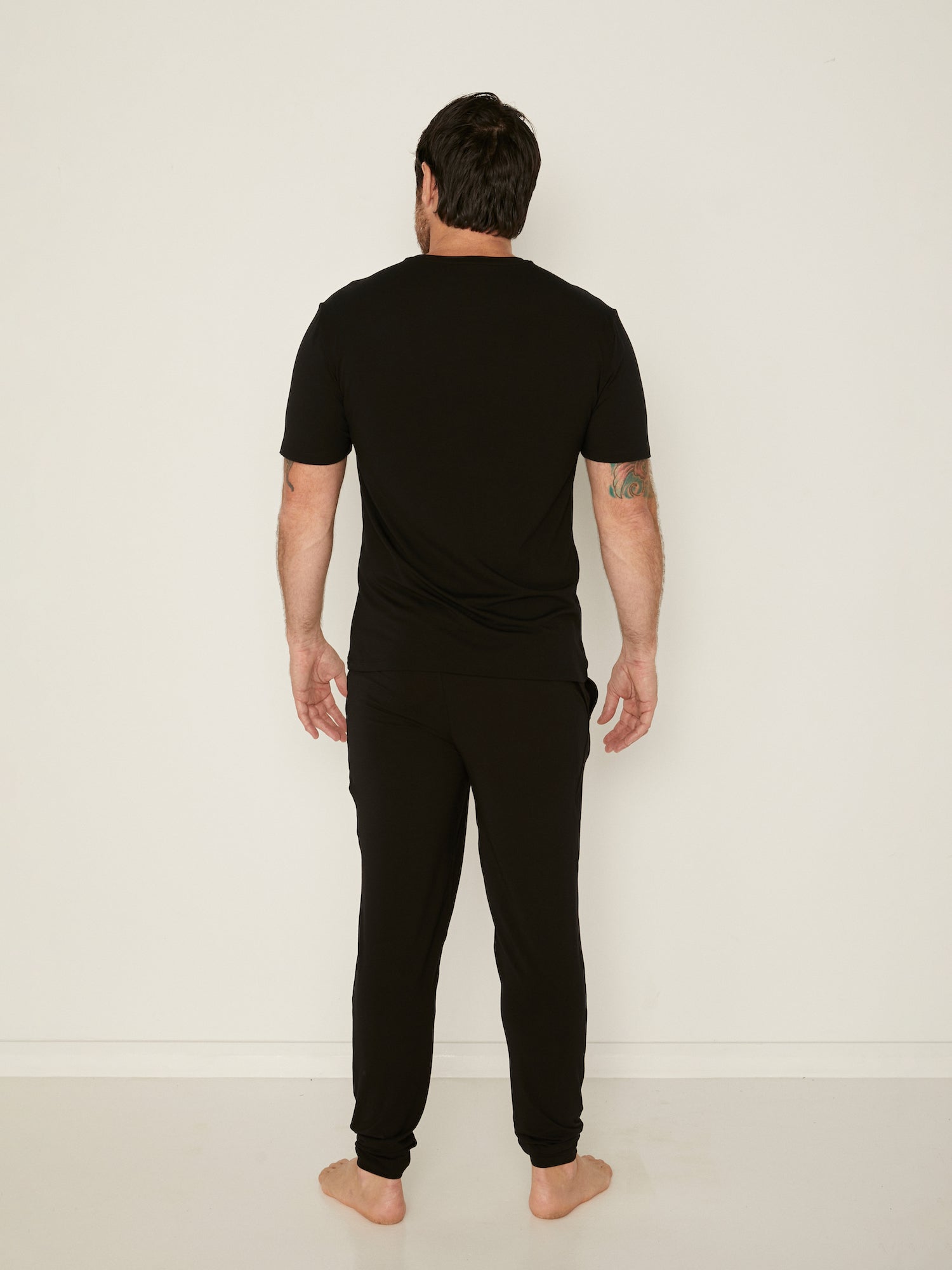 Male model wearing black generous classic fit tee, soft neckband, crew neckline, short sleeve, men's bamboo clothing