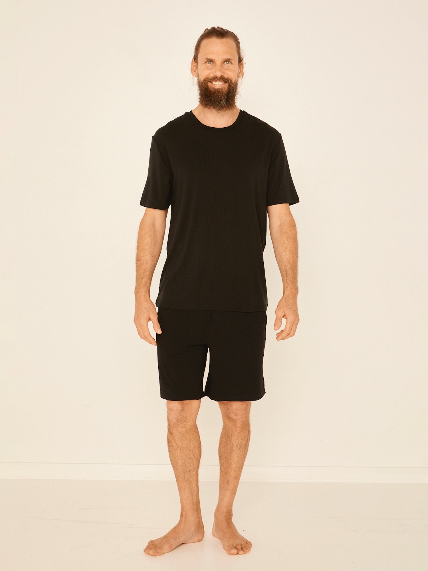Male model wearing black generous classic fit tee, soft neckband, crew neckline, short sleeve, men's bamboo clothing