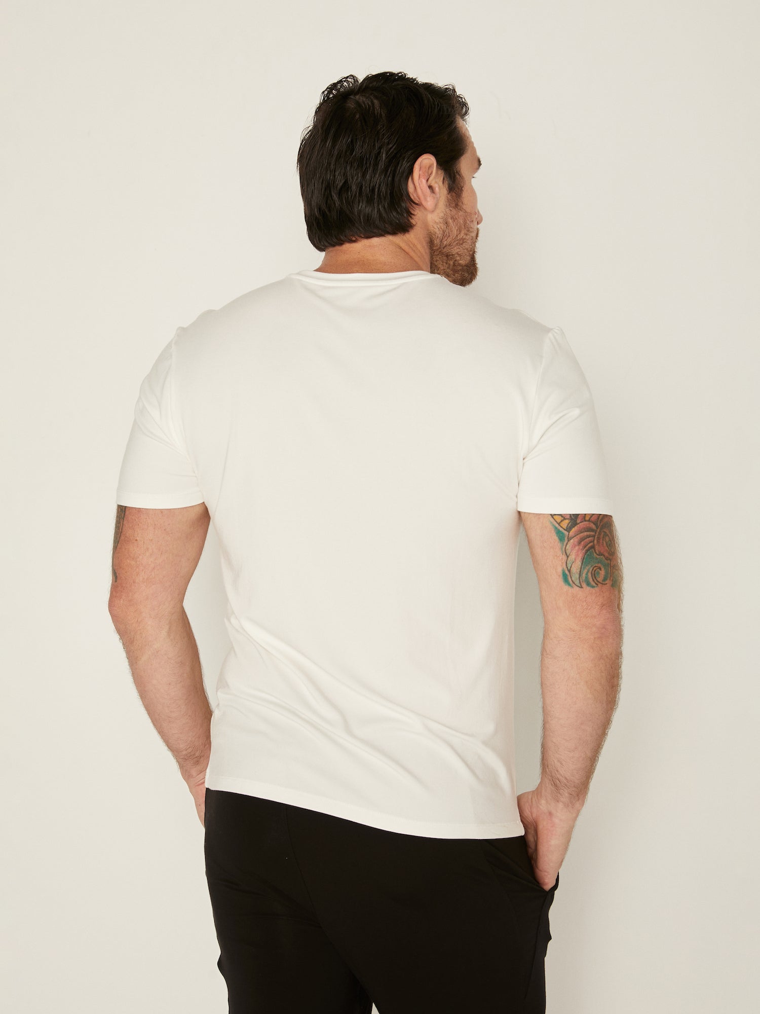 Male model wearing cream generous classic fit tee, soft neckband, crew neckline, short sleeve, men's bamboo clothing