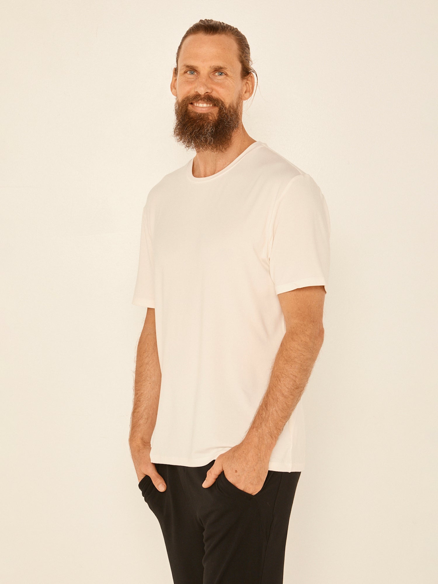 Male model wearing cream generous classic fit tee, soft neckband, crew neckline, short sleeve, men's bamboo clothing