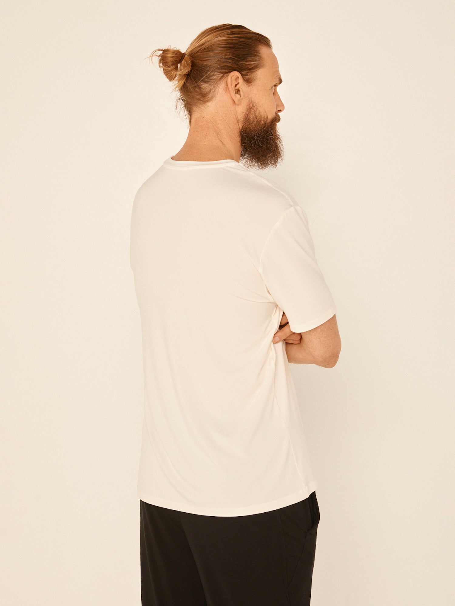 Male model wearing cream generous classic fit tee, soft neckband, crew neckline, short sleeve, men's bamboo clothing