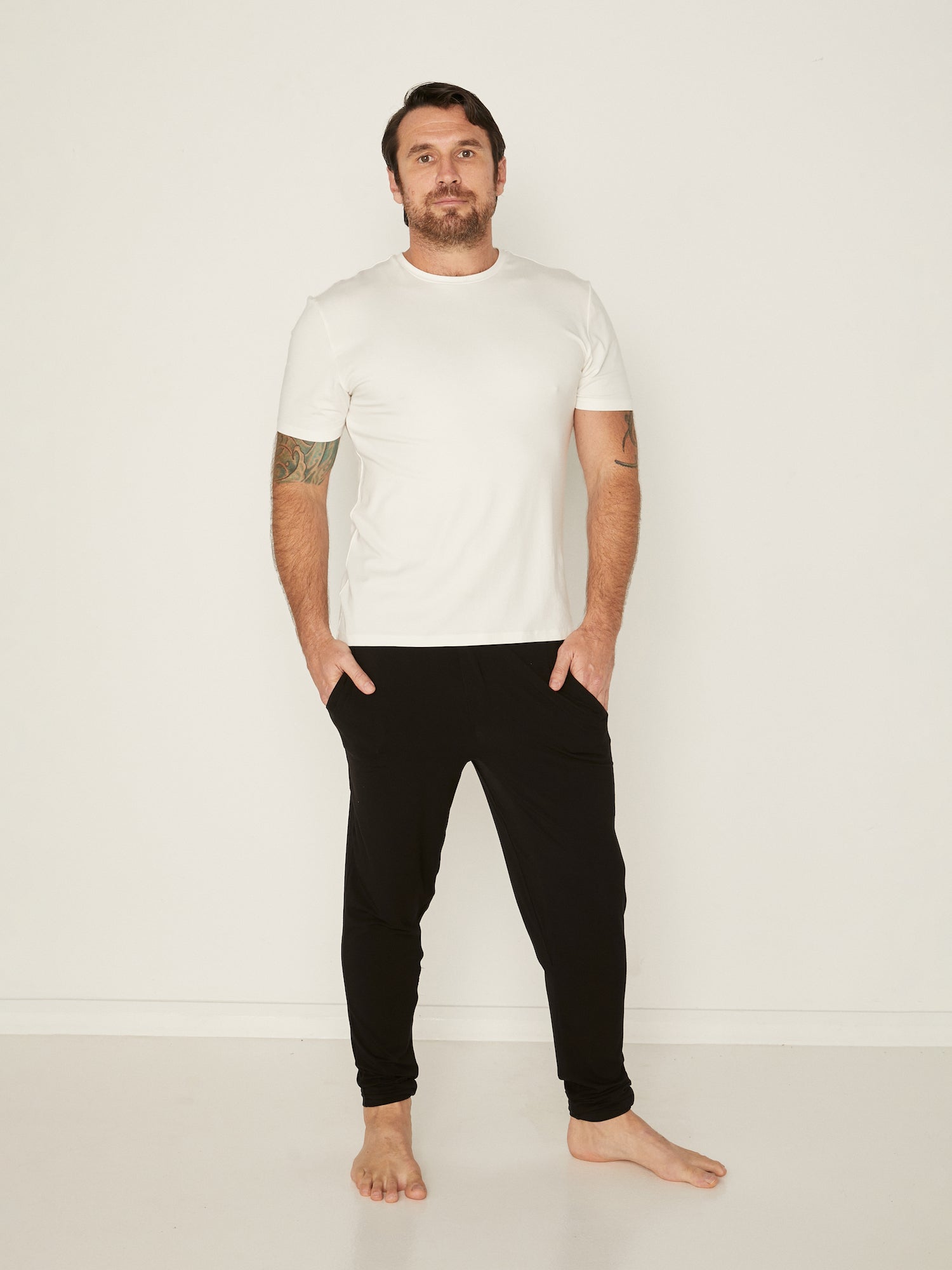 Male model wearing cream generous classic fit tee, soft neckband, crew neckline, short sleeve, men's bamboo clothing