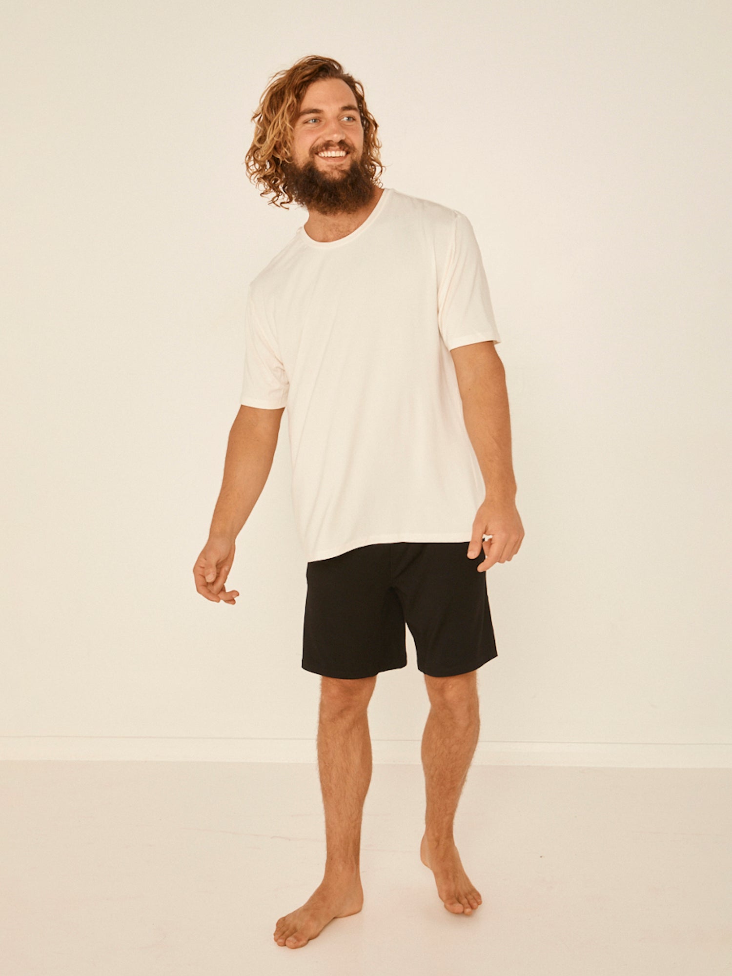 Male model wearing cream generous classic fit tee, soft neckband, crew neckline, short sleeve, men's bamboo clothing