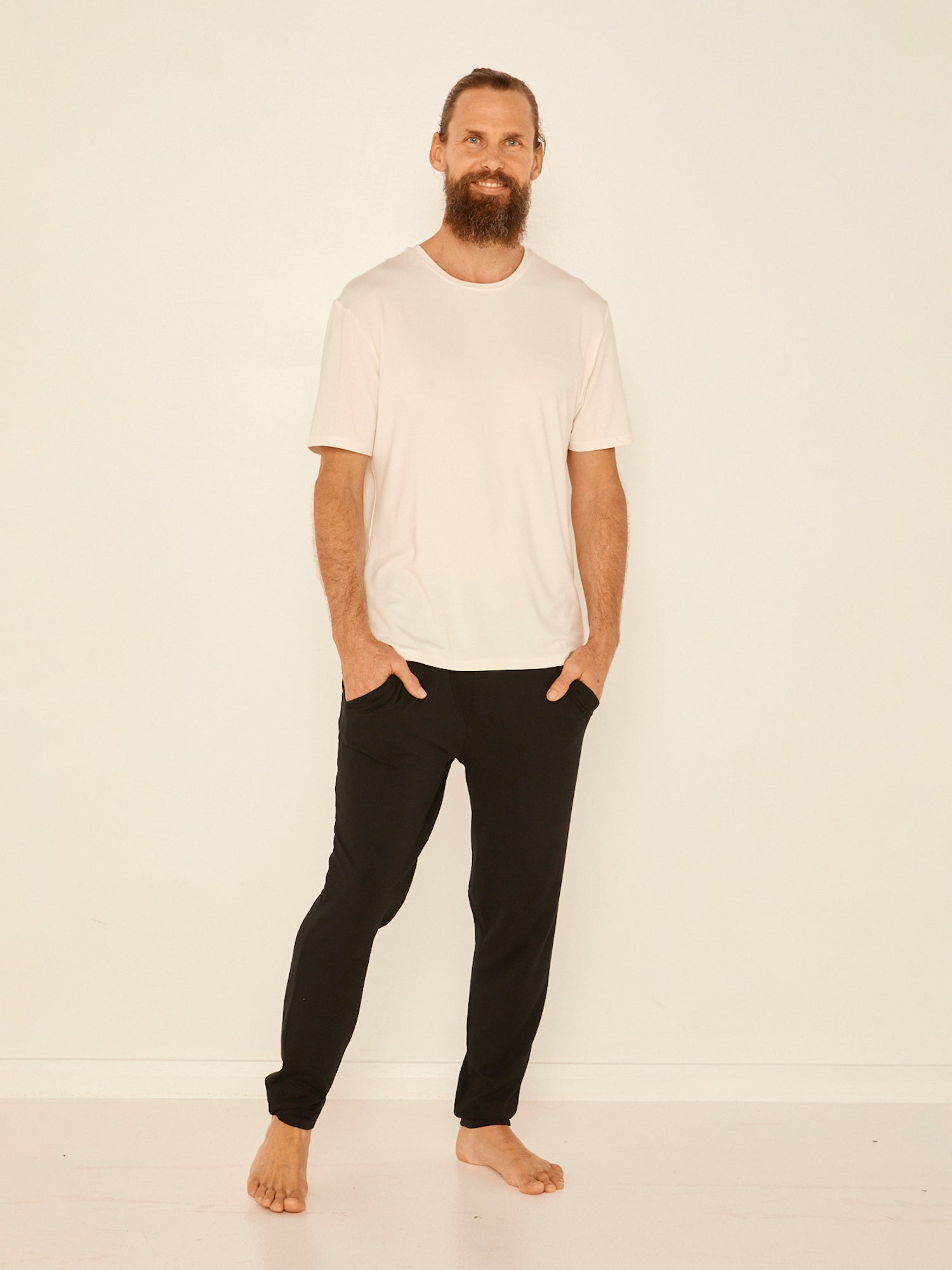 Male model wearing cream generous classic fit tee, soft neckband, crew neckline, short sleeve, men's bamboo clothing