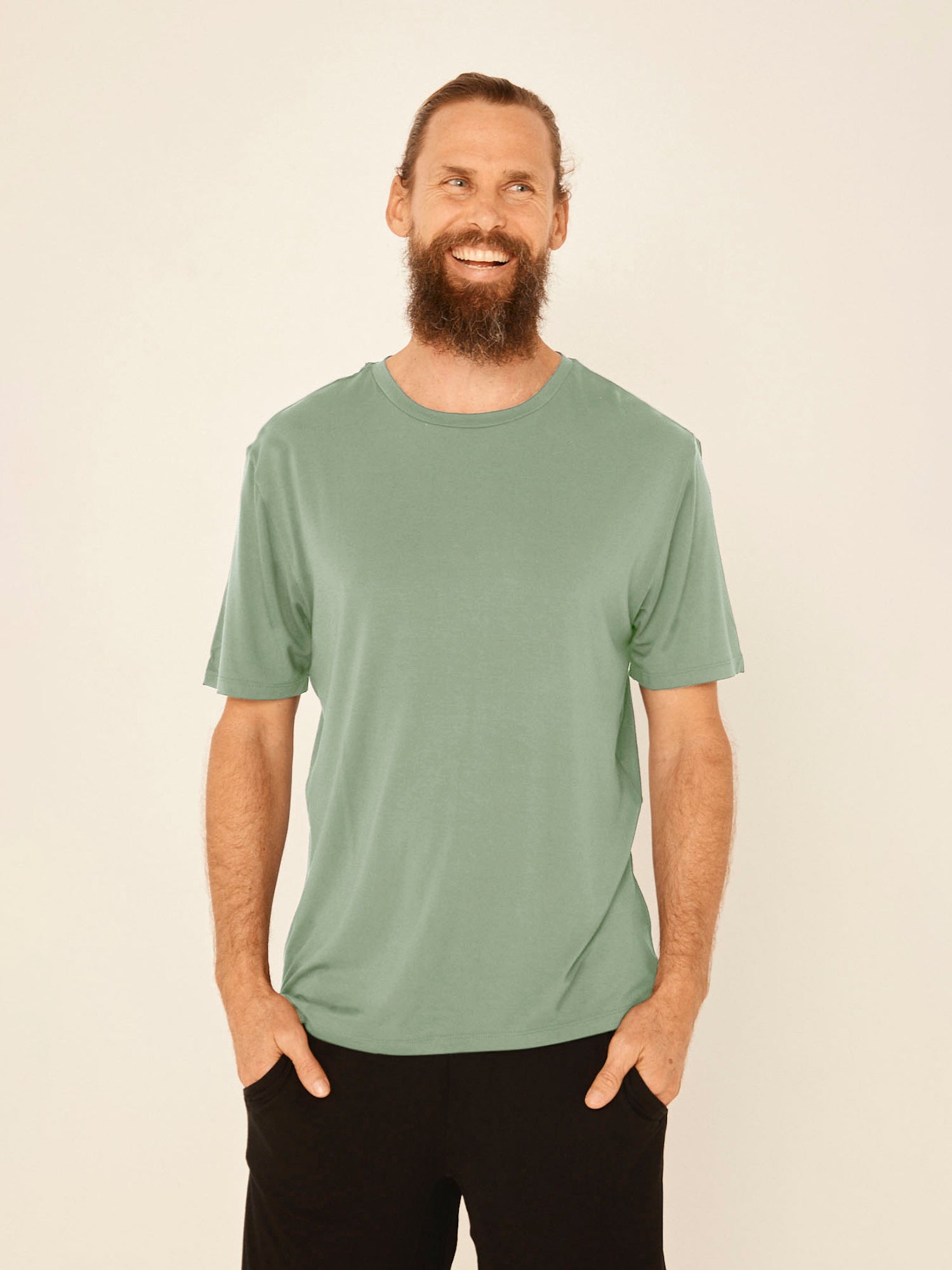 Male model wearing eucalyptus green generous classic fit tee, soft neckband, crew neckline, short sleeve, men's bamboo clothing