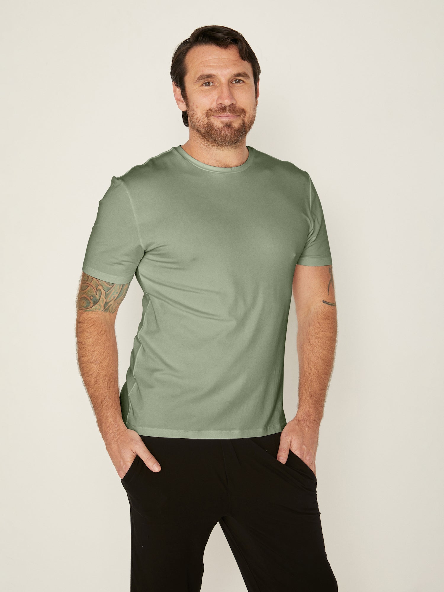 Male model wearing eucalyptus green generous classic fit tee, soft neckband, crew neckline, short sleeve, men's bamboo clothing