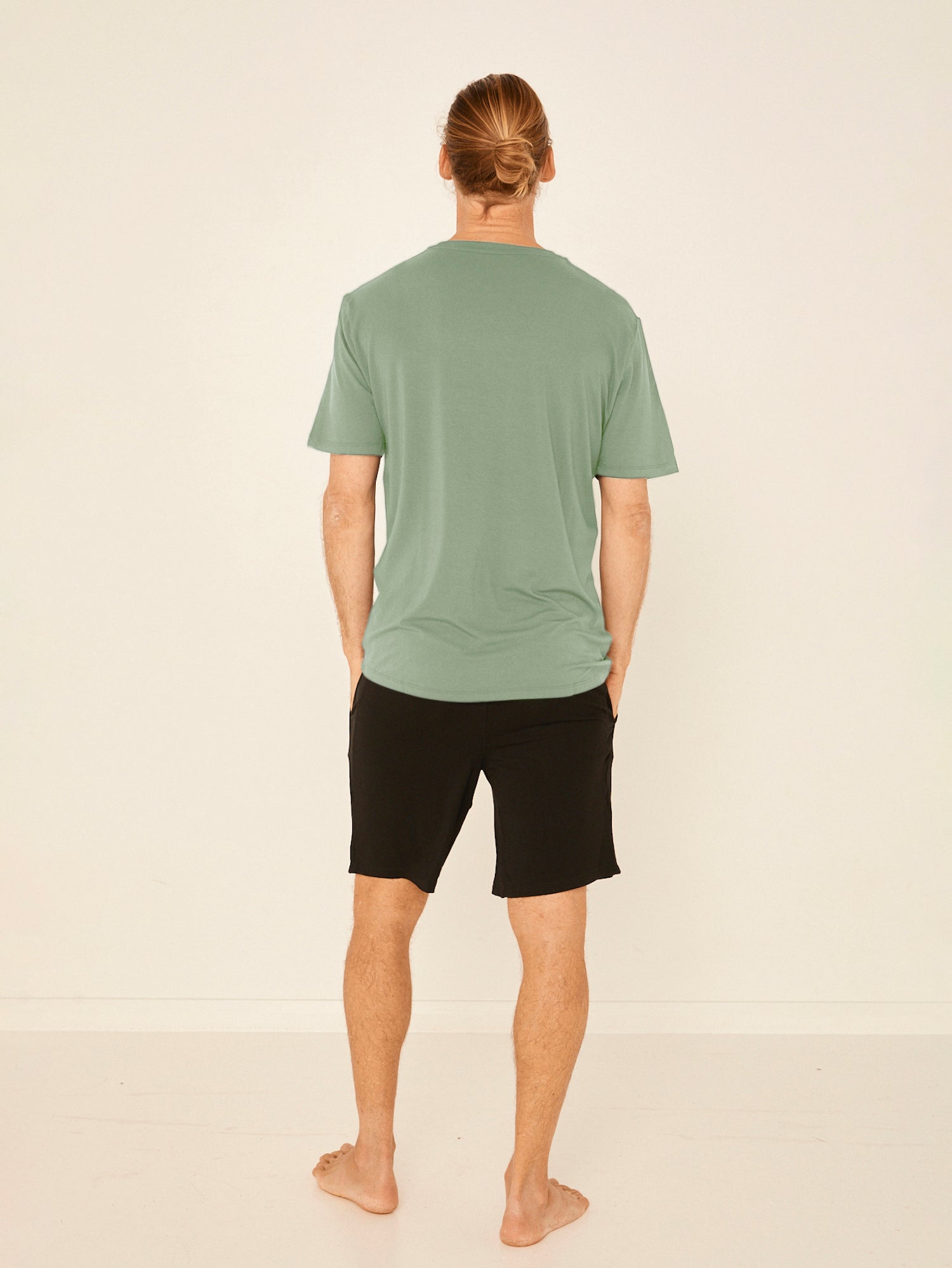 Male model wearing eucalyptus green generous classic fit tee, soft neckband, crew neckline, short sleeve, men's bamboo clothing