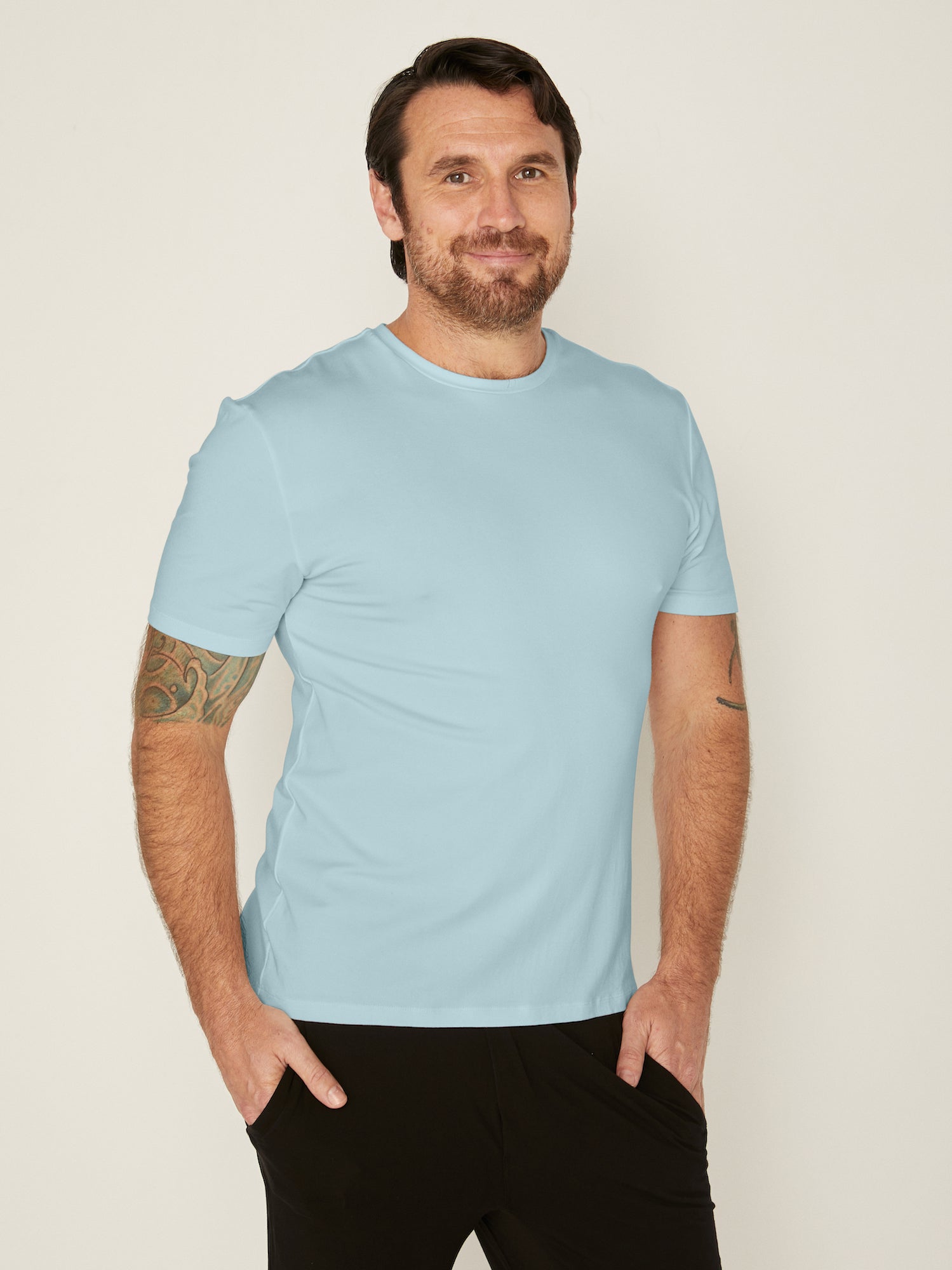 Male model wearing light topaz blue generous classic fit tee, soft neckband, crew neckline, short sleeve, men's bamboo clothing
