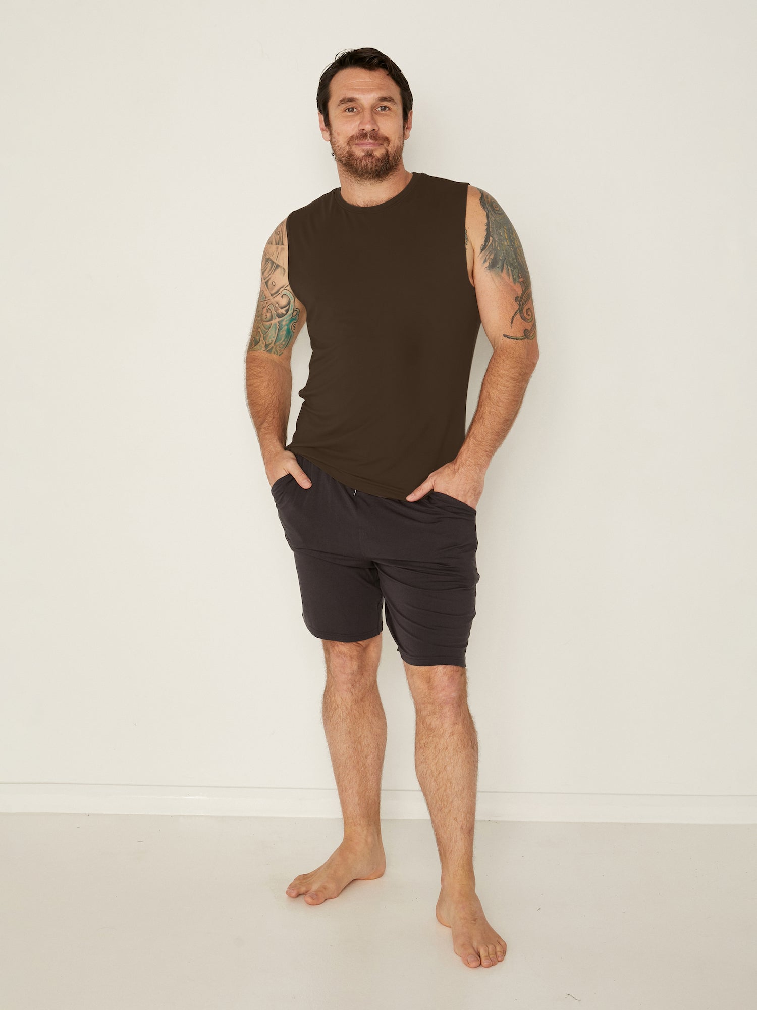 Male model wearing cocoa brown generous classic fit tank singlet, soft neckband, crew neckline, sleeveless, men's bamboo clothing