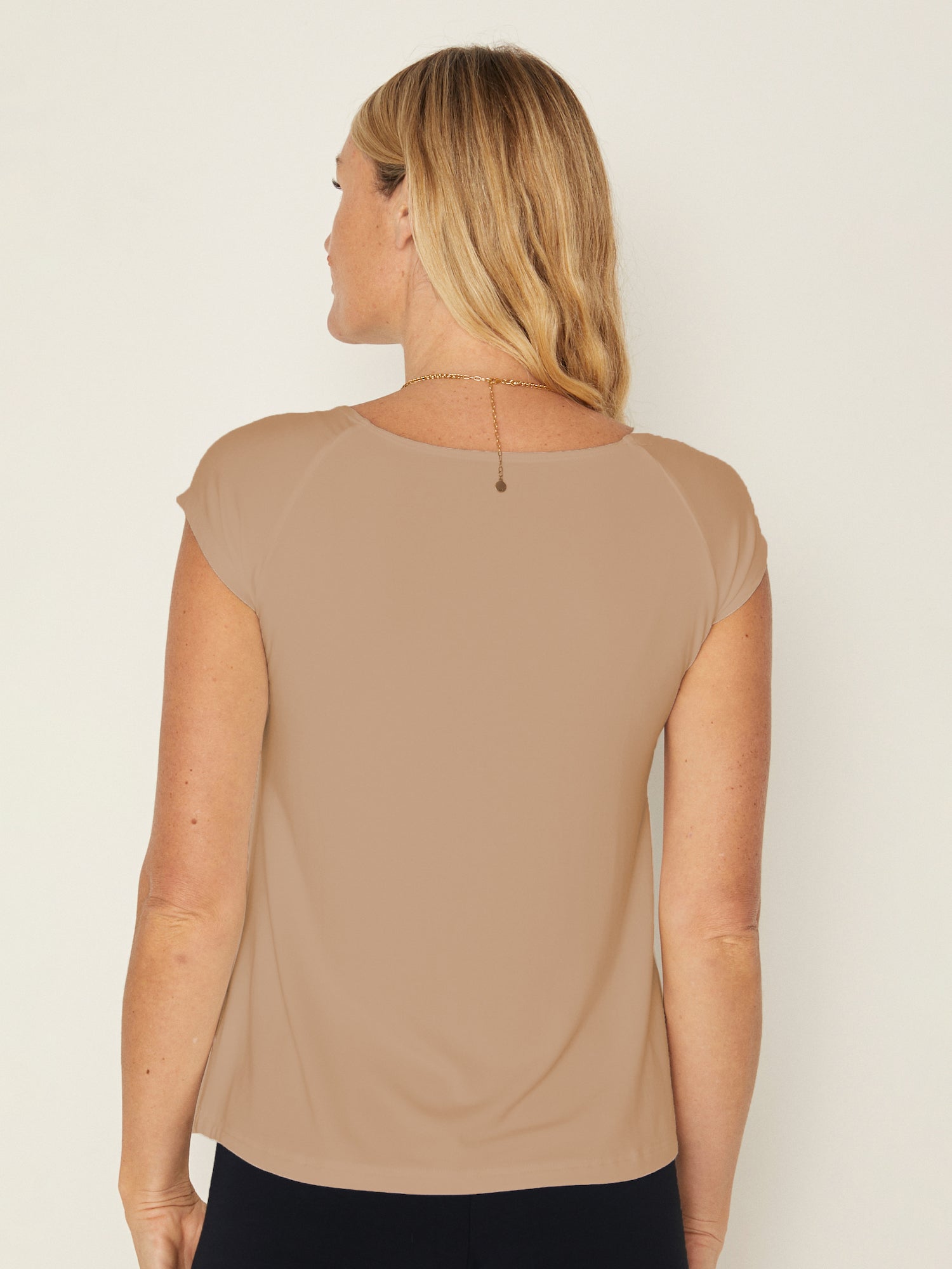Model wearing a caramel boat neck t-shirt with capped sleeves, fitted through shoulders and chest with loose fit to waist, women's bamboo clothing