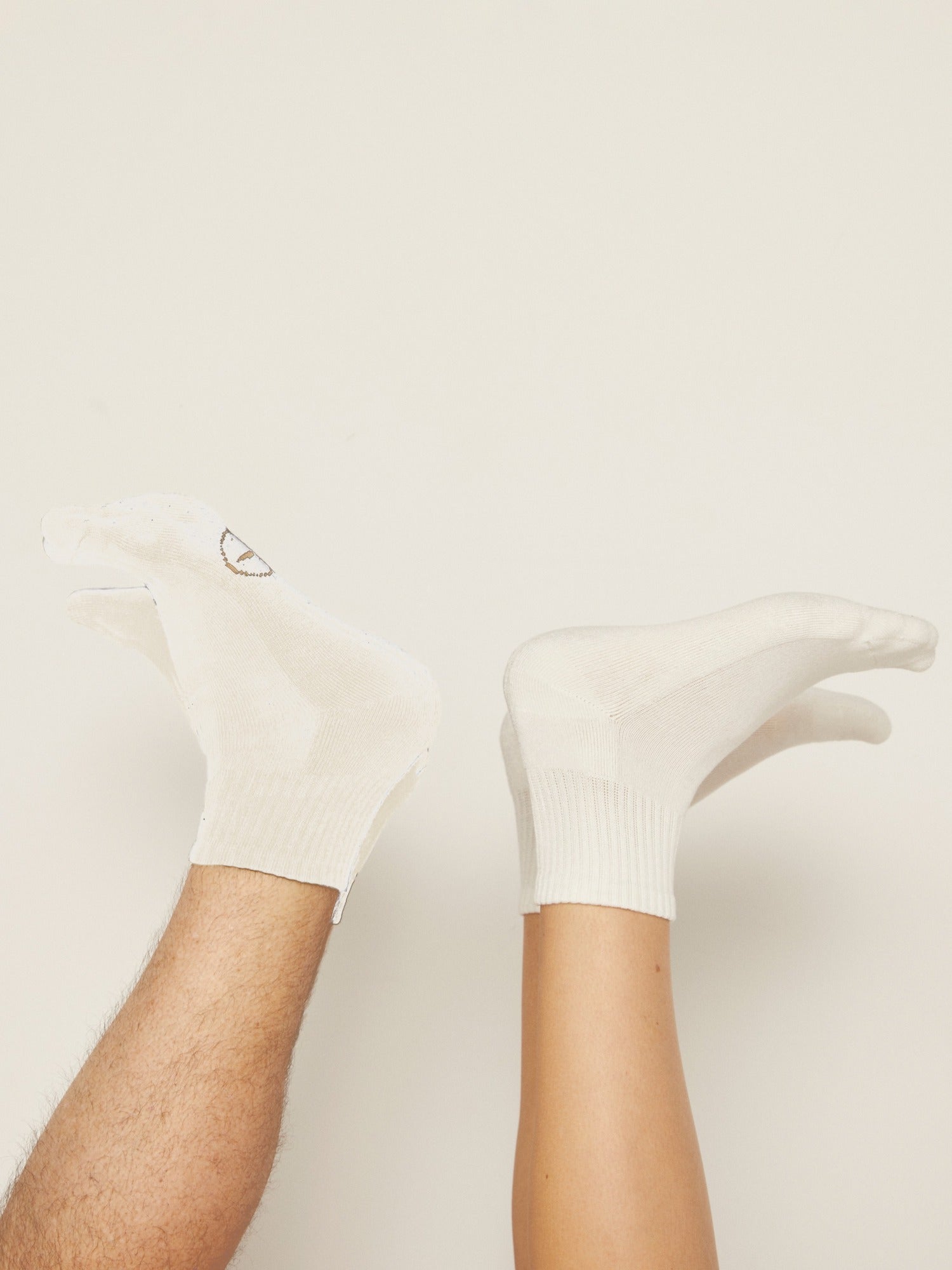 Model wearing white bamboo crew socks, mid to low rise, ribbed ankle support and cushioned sole, bamboo sport sock