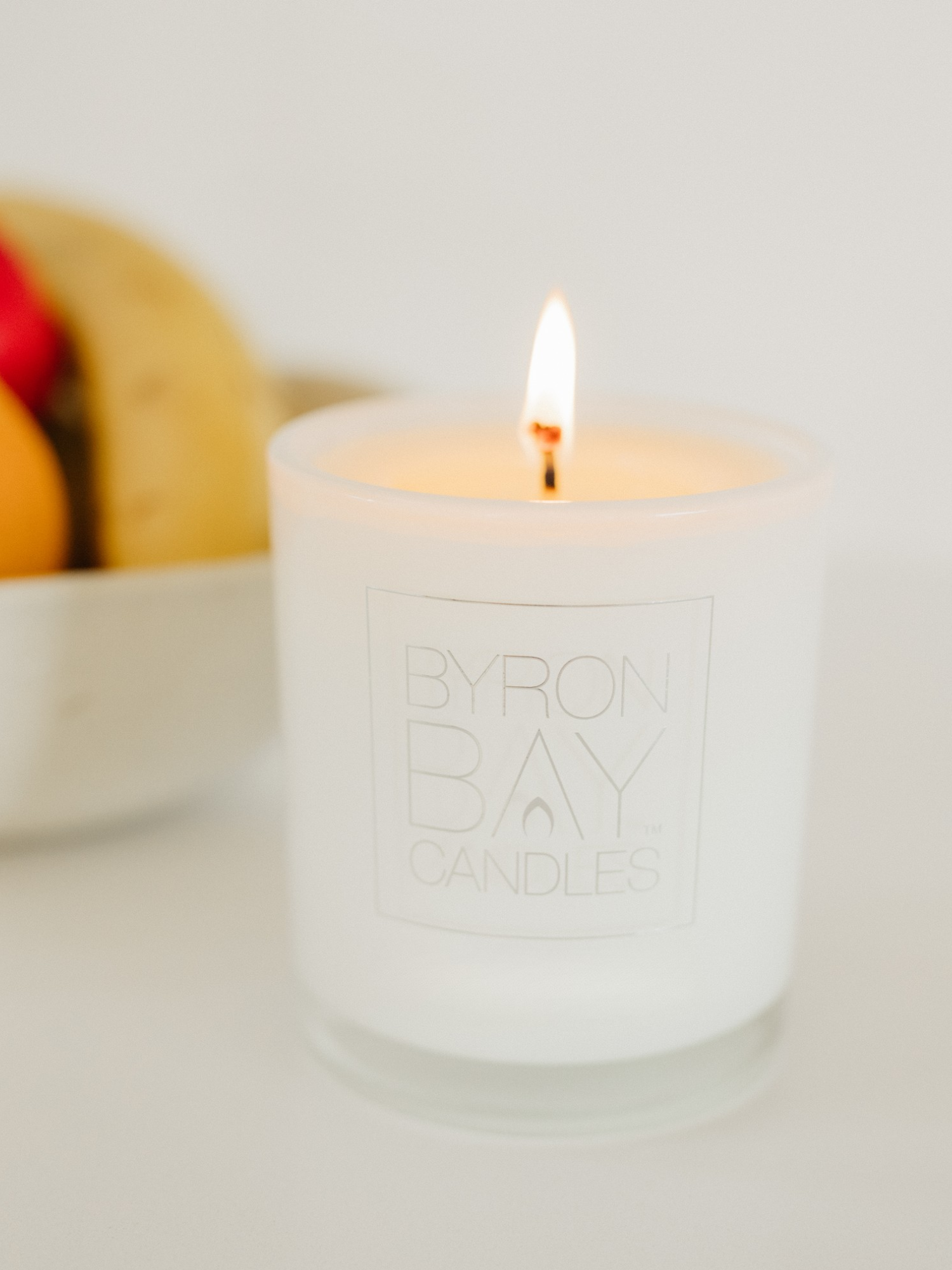 Candle with 'Byron Bay Candles' branding on a neutral background
