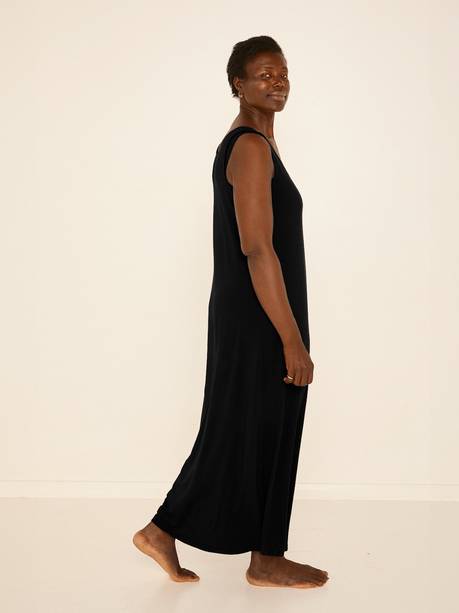 Model wearing a reversible black maxi length dress with scoop and boat necklines, women's bamboo clothing