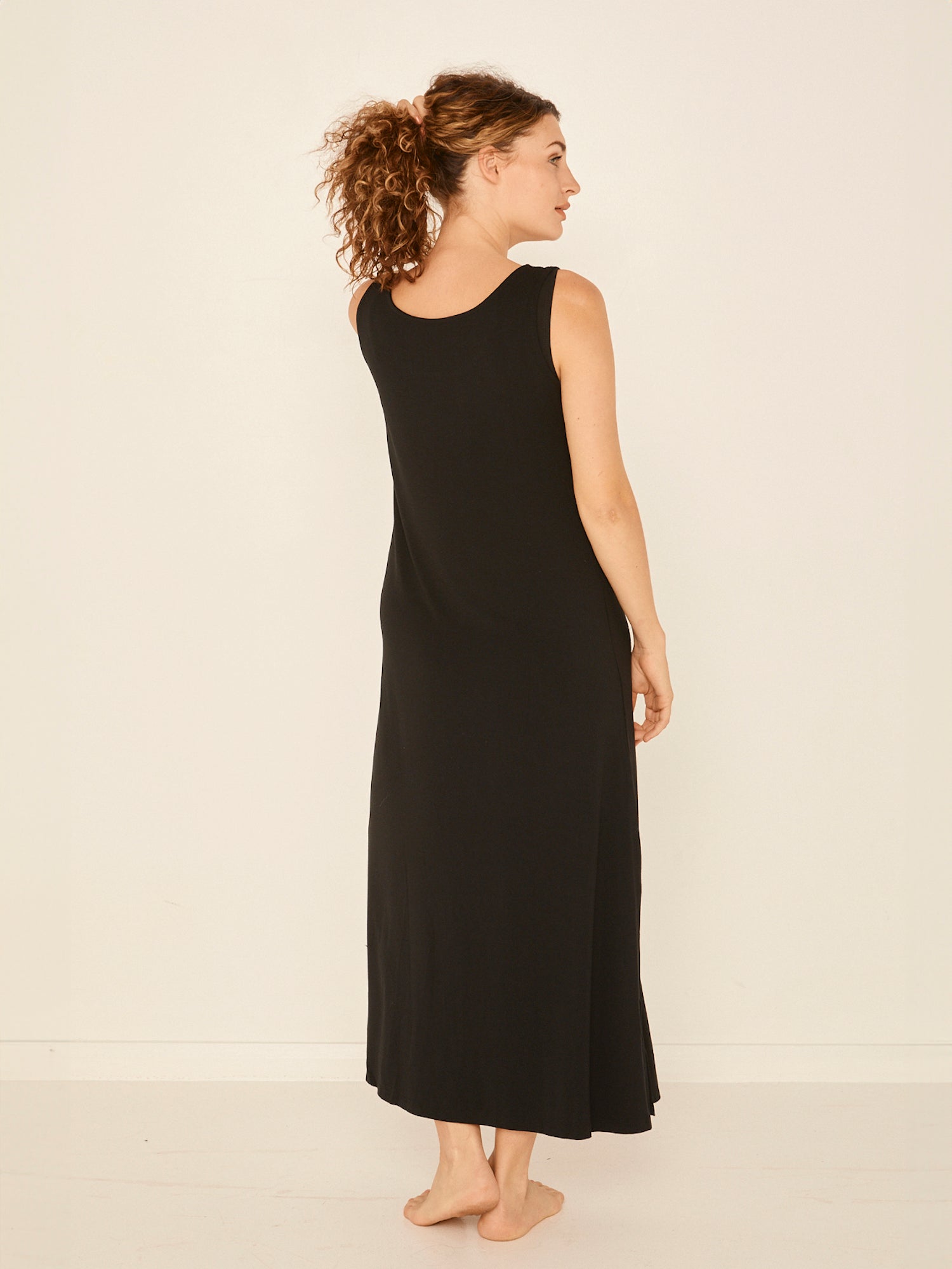 Model wearing a reversible black maxi length dress with scoop and boat necklines, women's bamboo clothing